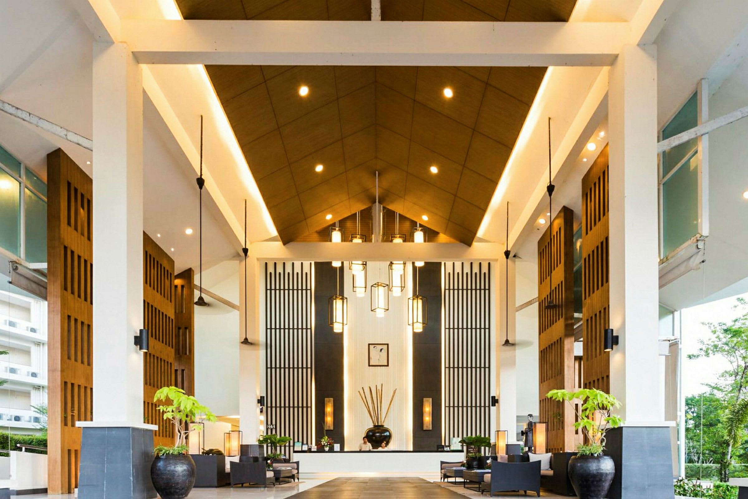 En hotellobby med højt loft, moderne design og dekorative lamper. (AI-genereret tekst)