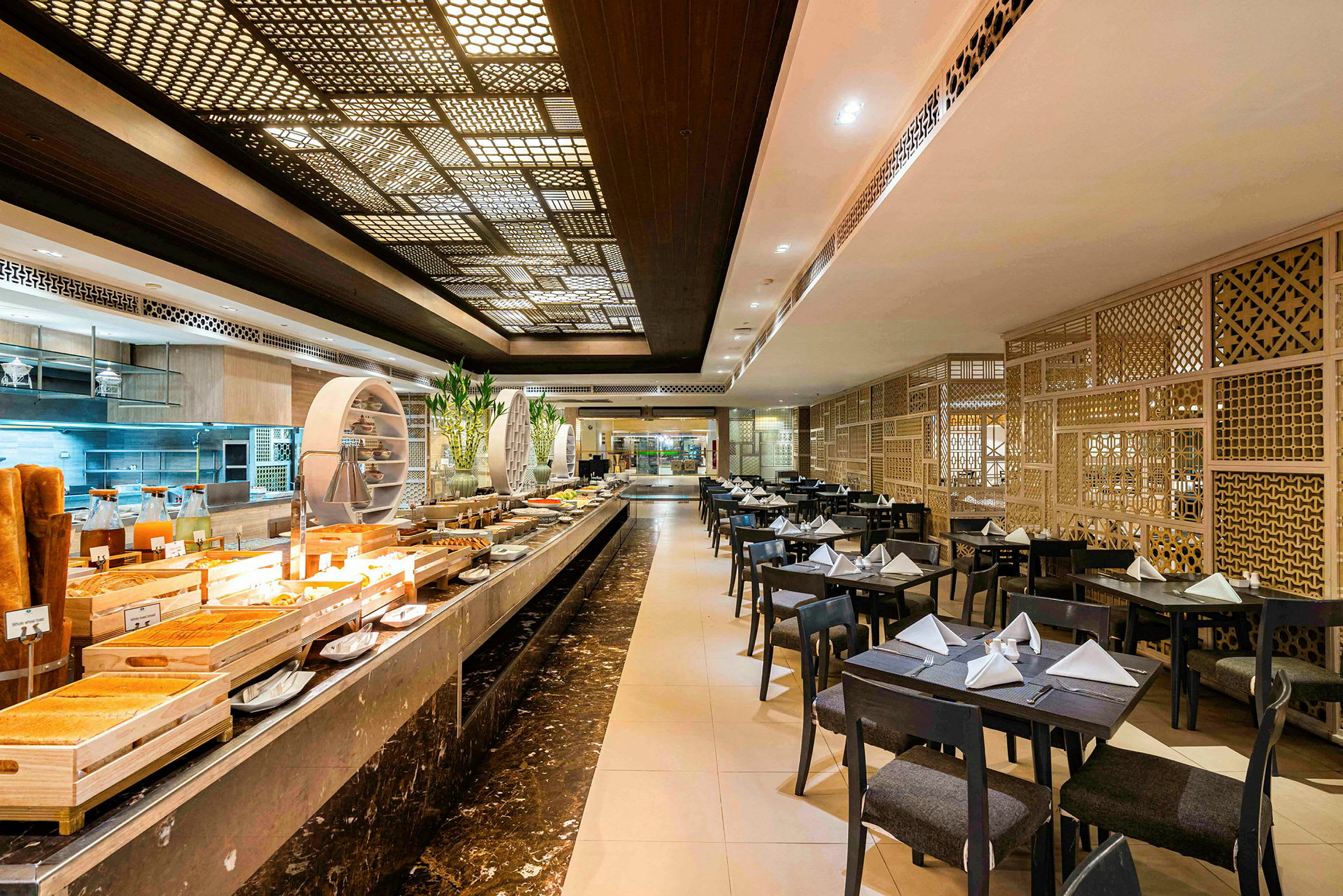 Interiør af en restaurant med dækkede borde og en buffet med anrettede retter. (AI-genereret tekst)