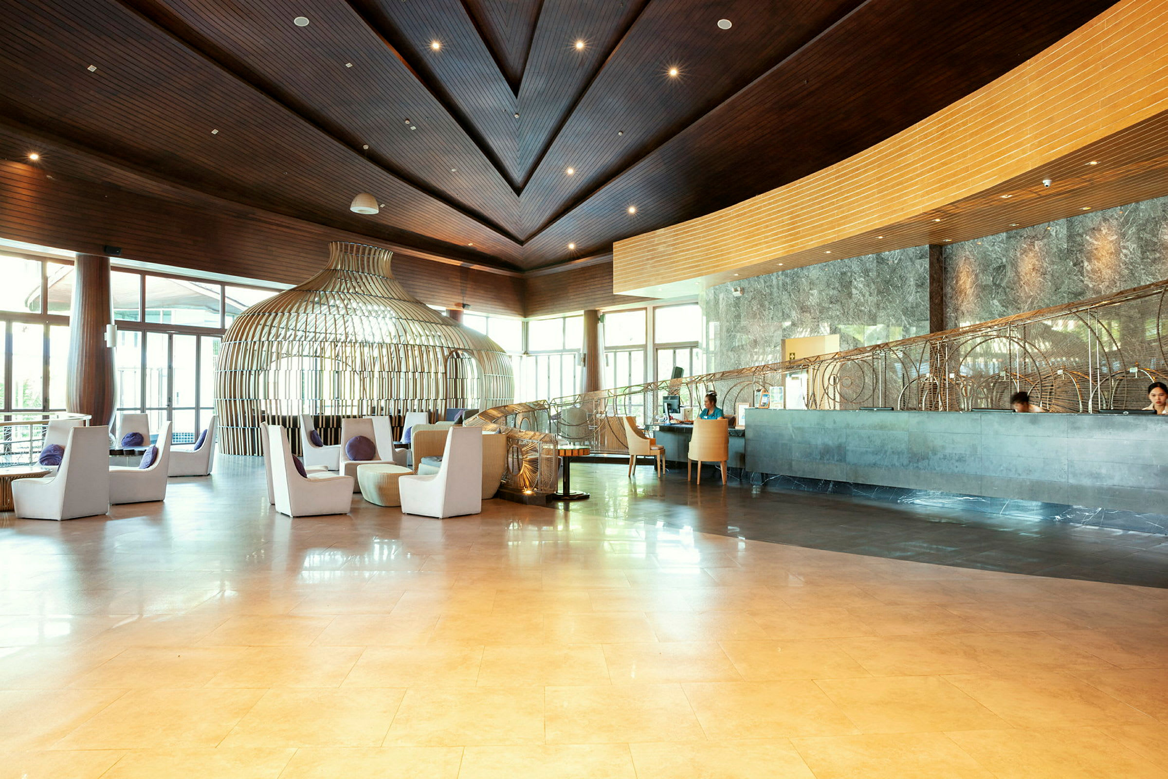En elegant hotellobby med siddeområder, moderne indretning og store vinduer. (AI-genereret tekst)