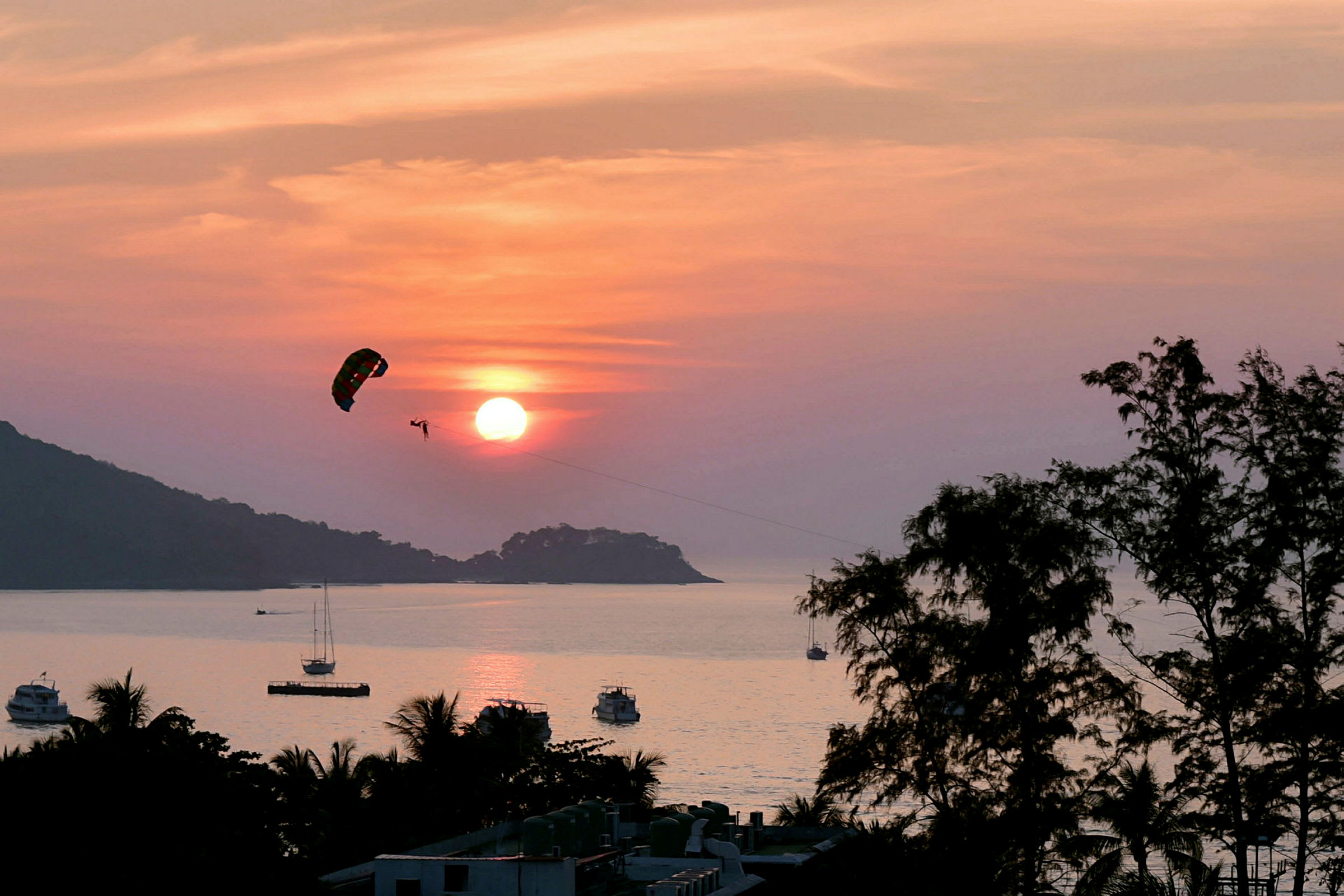 Person, der udfører parasailing over havet ved solnedgang. (AI-genereret tekst)