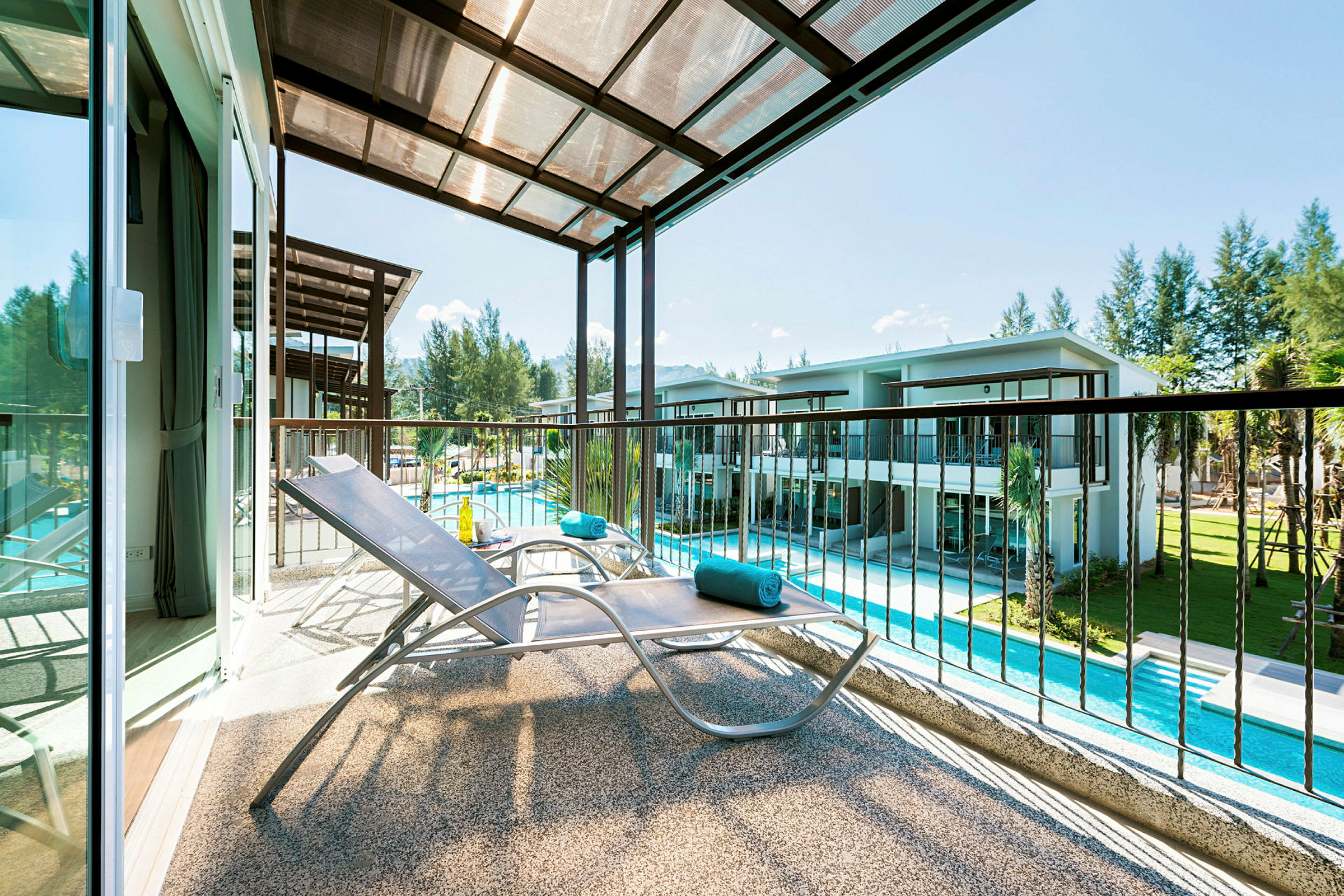 En altan med en solvogn og udsigt over en swimmingpool og grønne områder. (AI-genereret tekst)