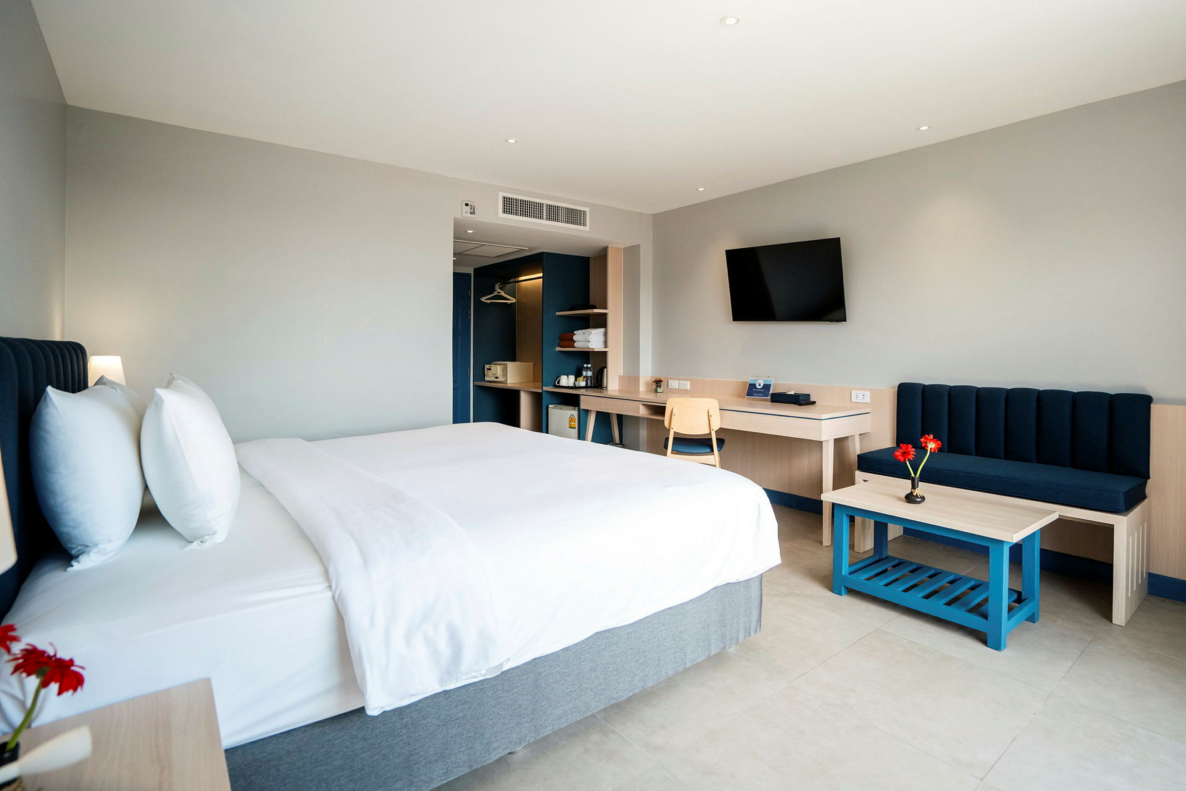 Et moderne hotelværelse med en dobbeltseng, sofa og skrivebord. (AI-genereret tekst)