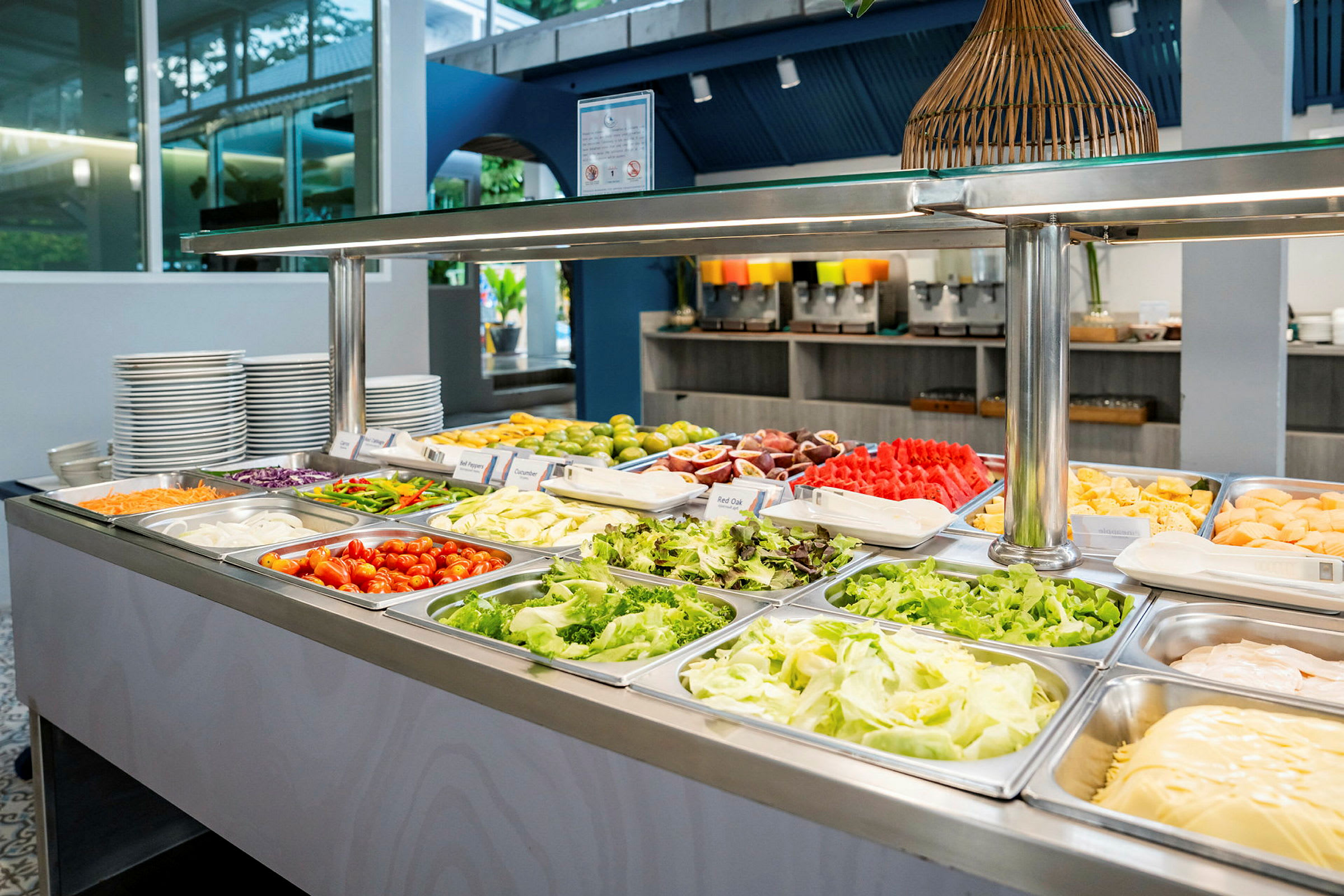 En buffet med friske grøntsager og frugter i en spisesal. (AI-genereret tekst)