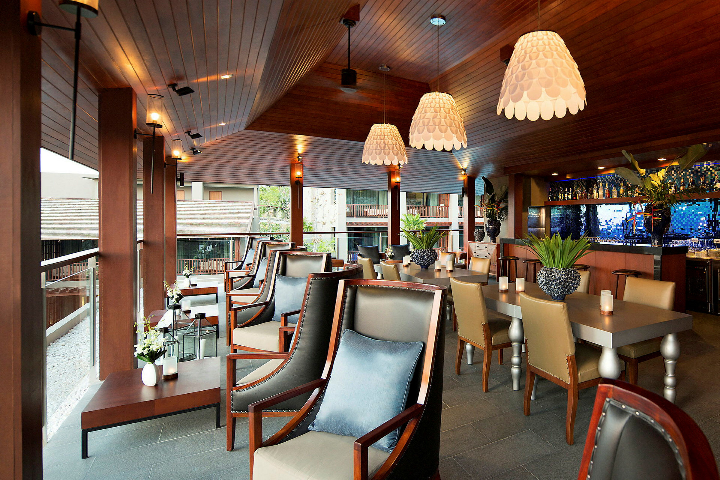Interiør af en moderne restaurant eller bar med elegant træindretning, komfortable siddepladser og dekorative lamper. (AI-genereret tekst)