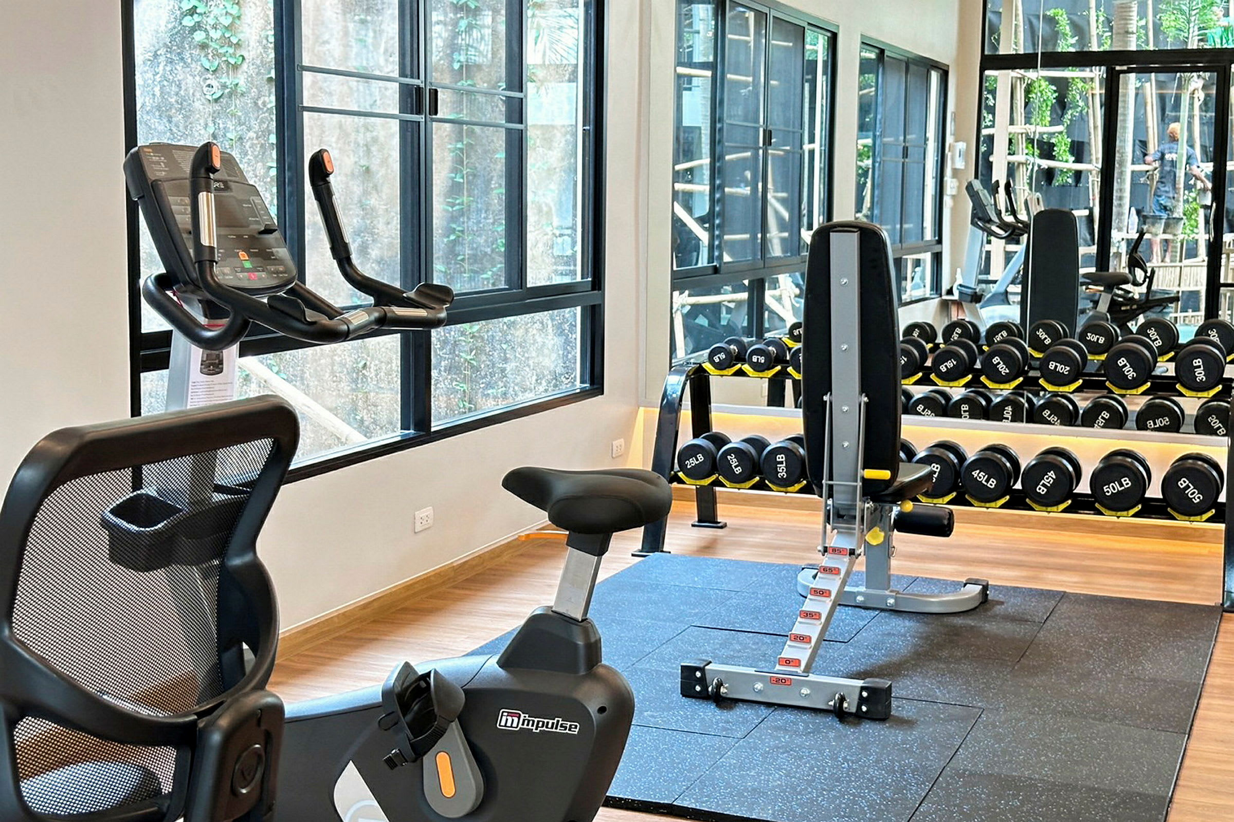 Interiørbillede af et fitnesscenter med træningsudstyr såsom motionscykel og håndvægte. (AI-genereret tekst)