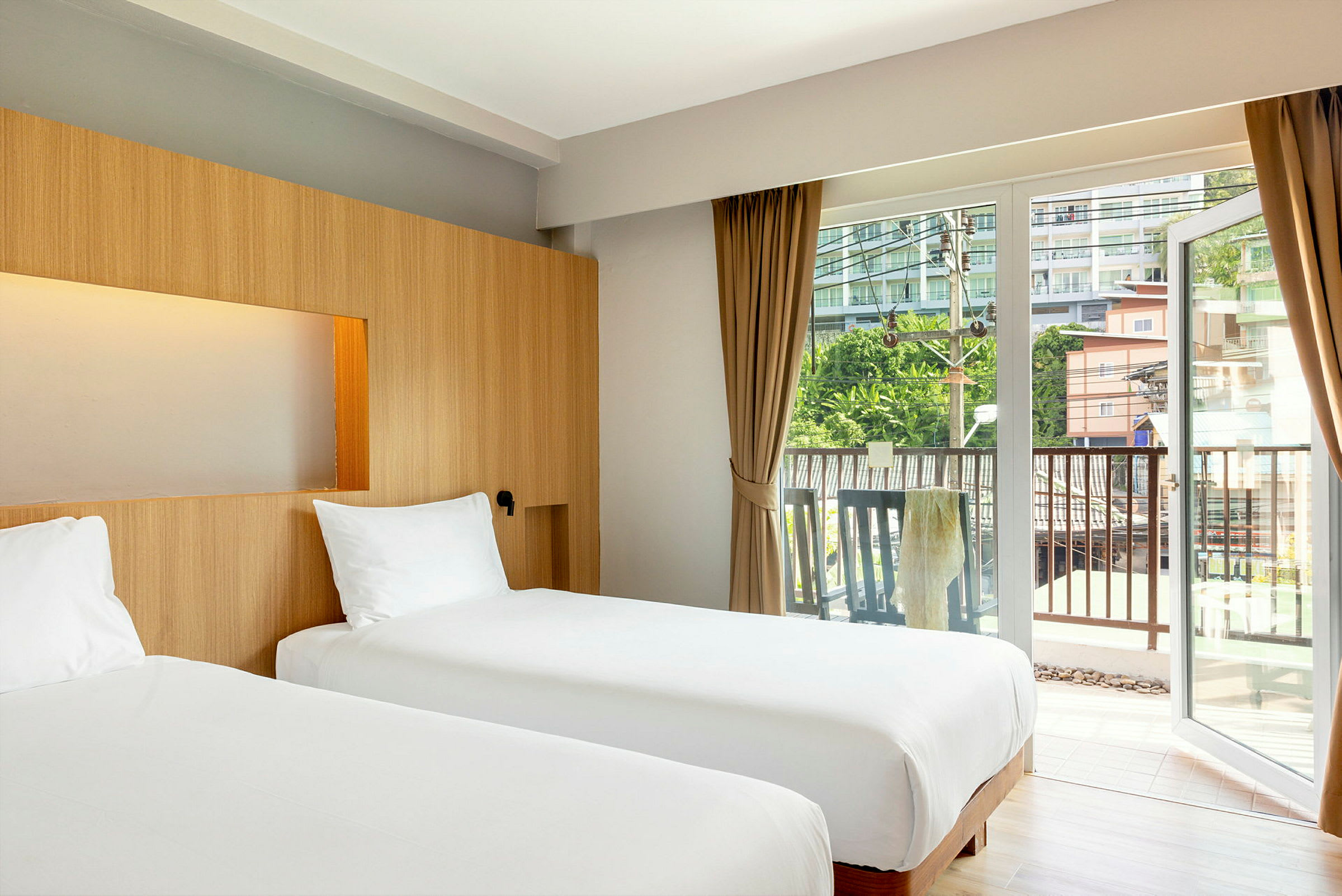 To enkeltsenge på et hotelværelse med store glasdøre ud mod en balkon. (AI-genereret tekst)
