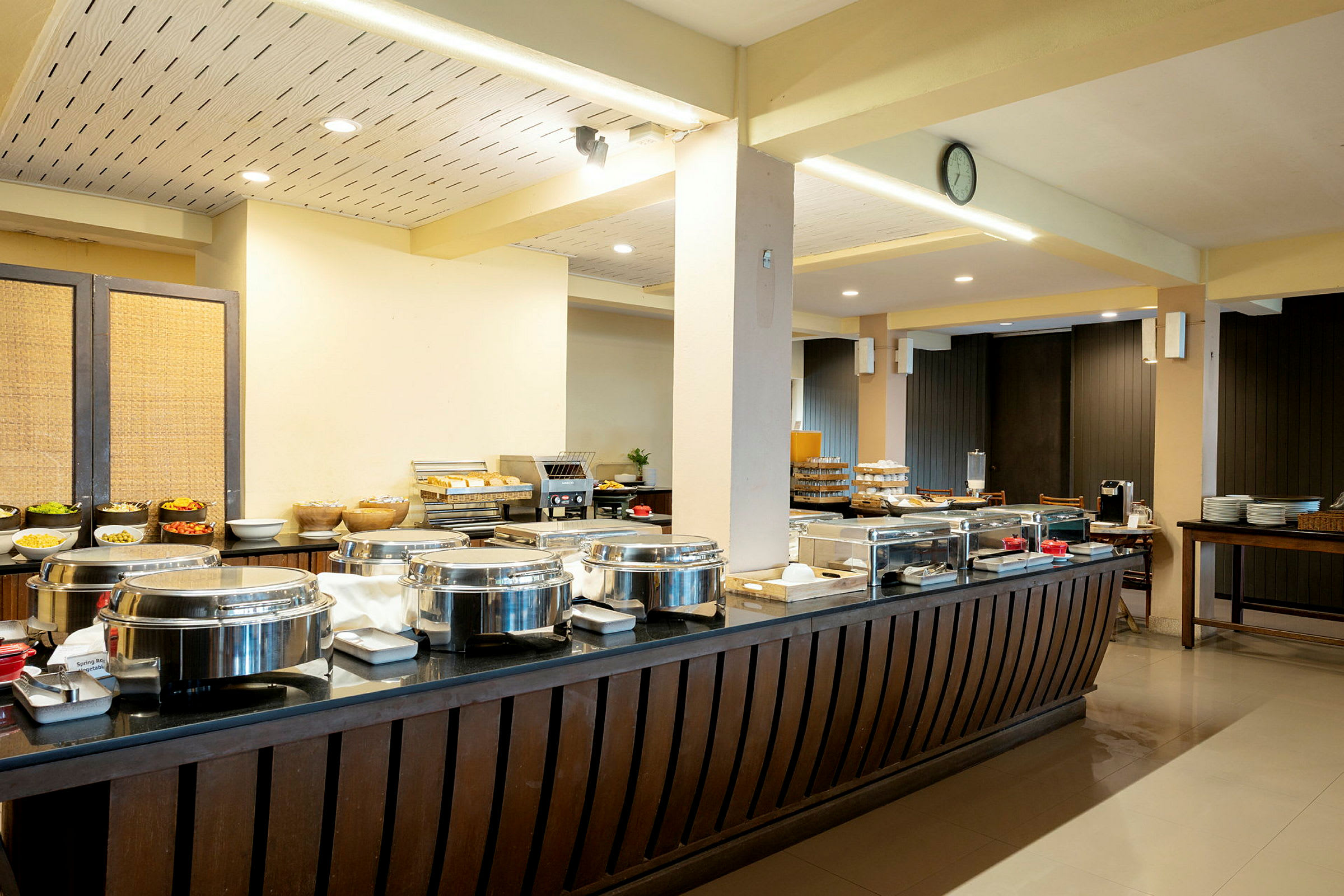 Buffetrestaurant med borde fyldt med varmebeholdere og mad. (AI-genereret tekst)