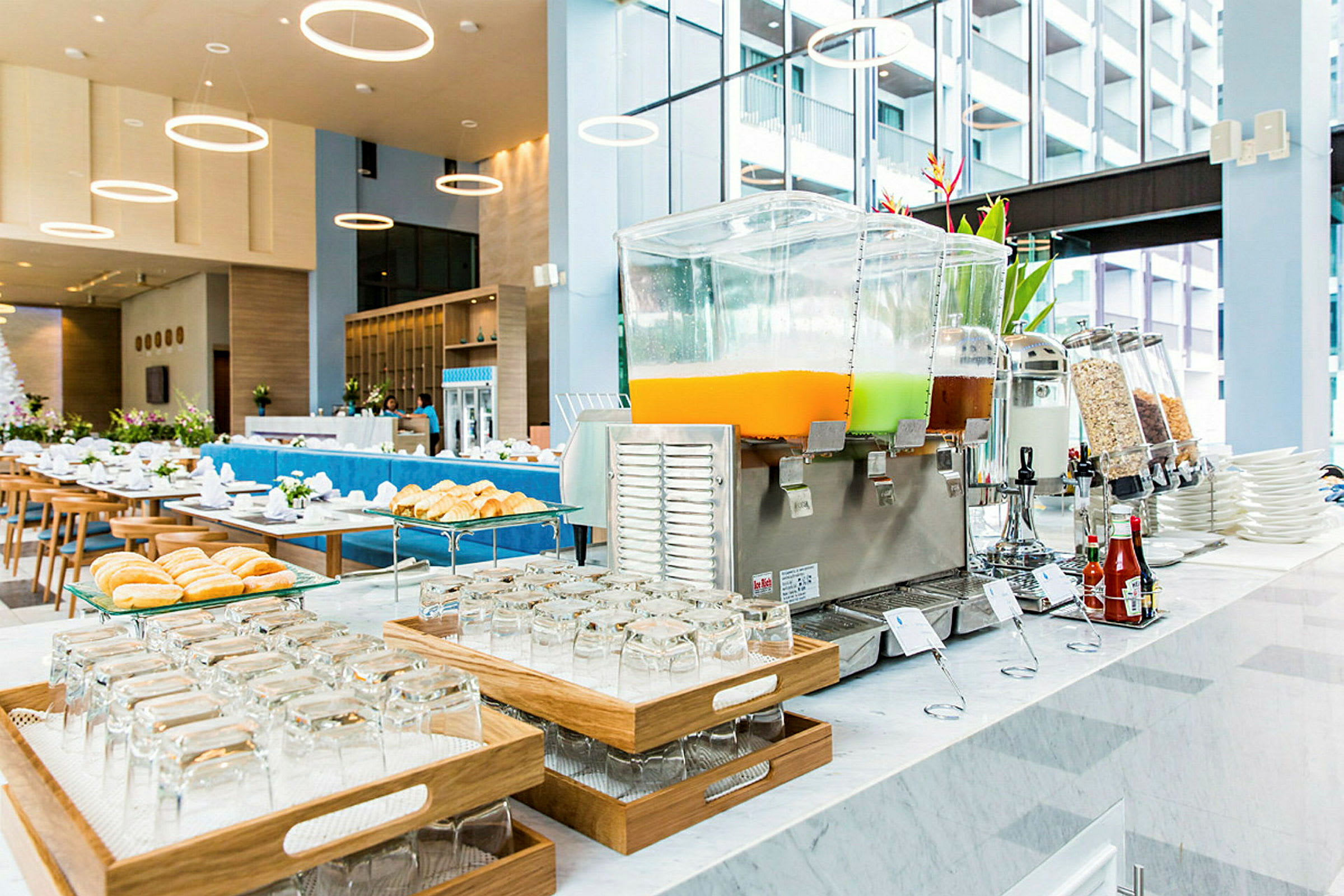 Morgenmadsbuffet med juiceautomater og bagværk på et moderne hotel. (AI-genereret tekst)