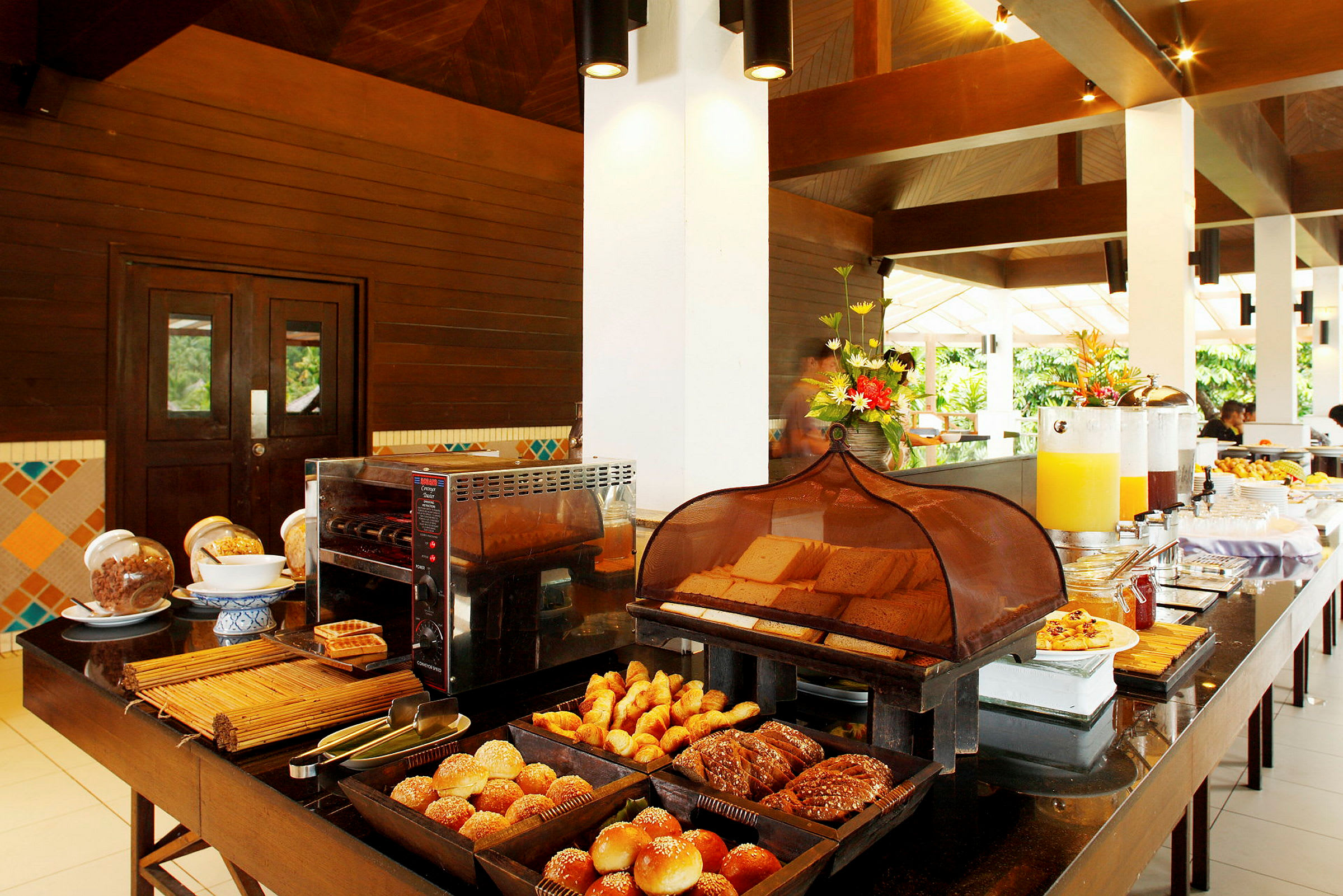 Hotelmorgenmad med brød, croissanter og drikkevarer på et buffetbord. (AI-genereret tekst)