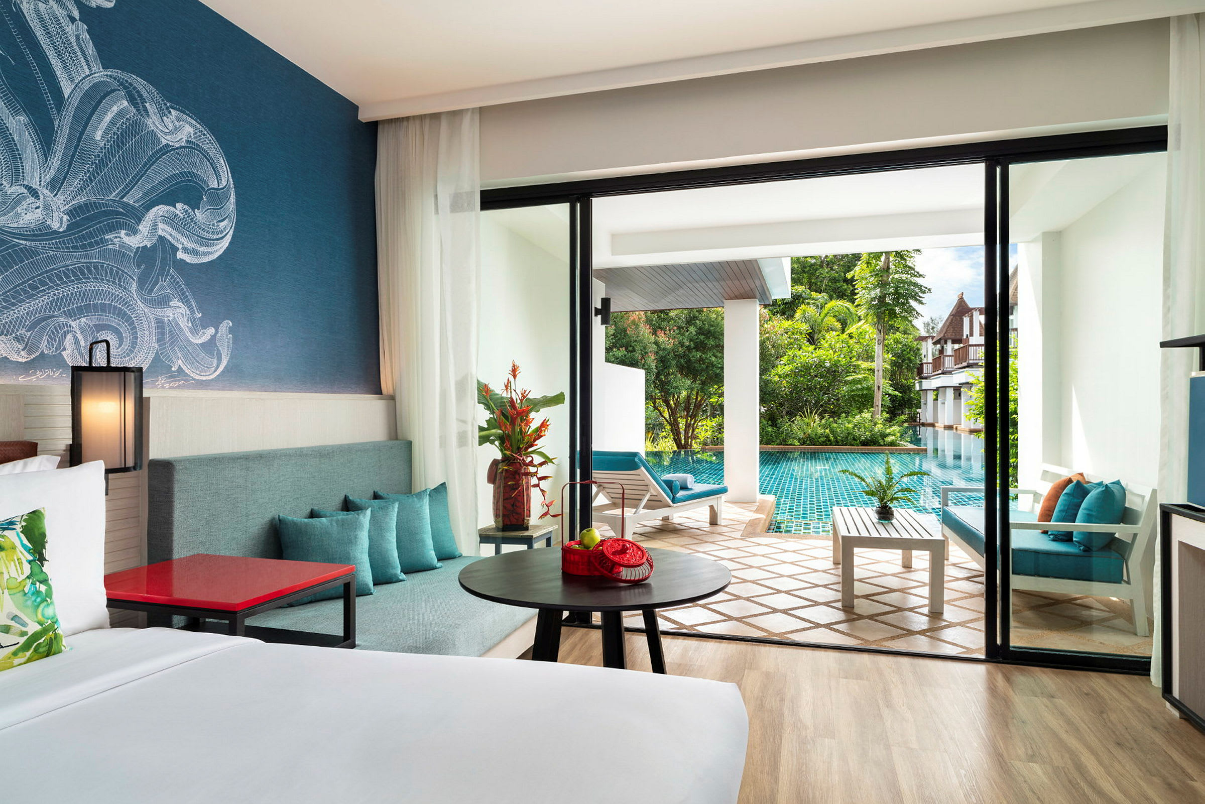 Hotelværelse med moderne møbler, en stor seng og en terrasse, der fører ud til en pool i et frodigt område. (AI-genereret tekst)