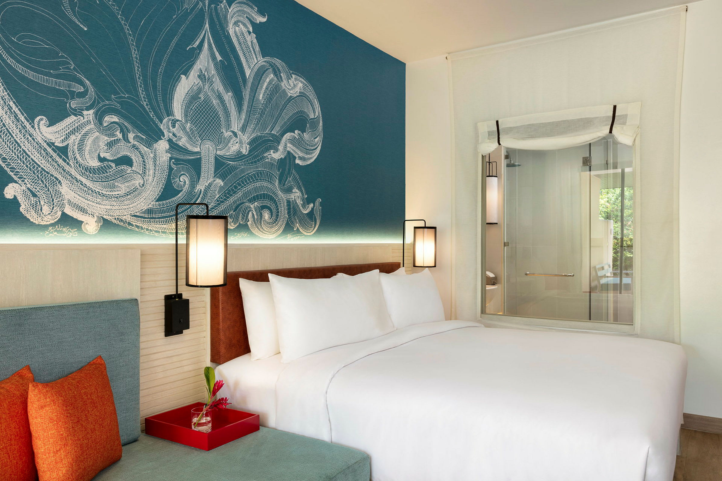 Et moderne hotelværelse med en stor seng og farverige puder. Vægsdekorationen er detaljeret og giver rummet en hyggelig atmosfære. (AI-genereret tekst)