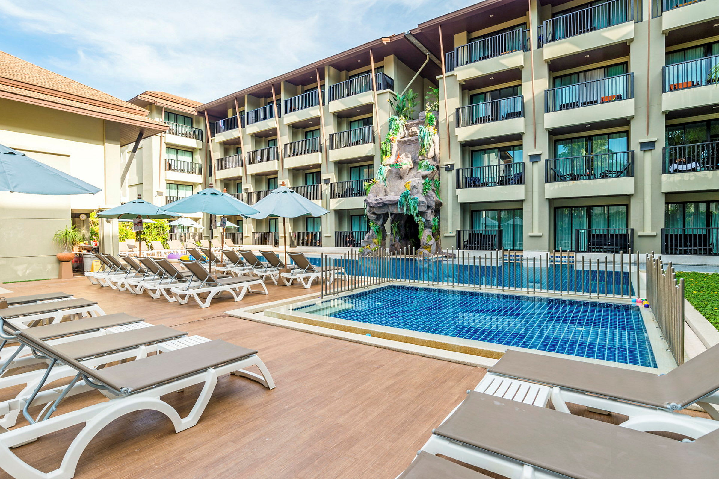 Udendørs pool med liggestole og parasoller ved et hotel. (AI-genereret tekst)