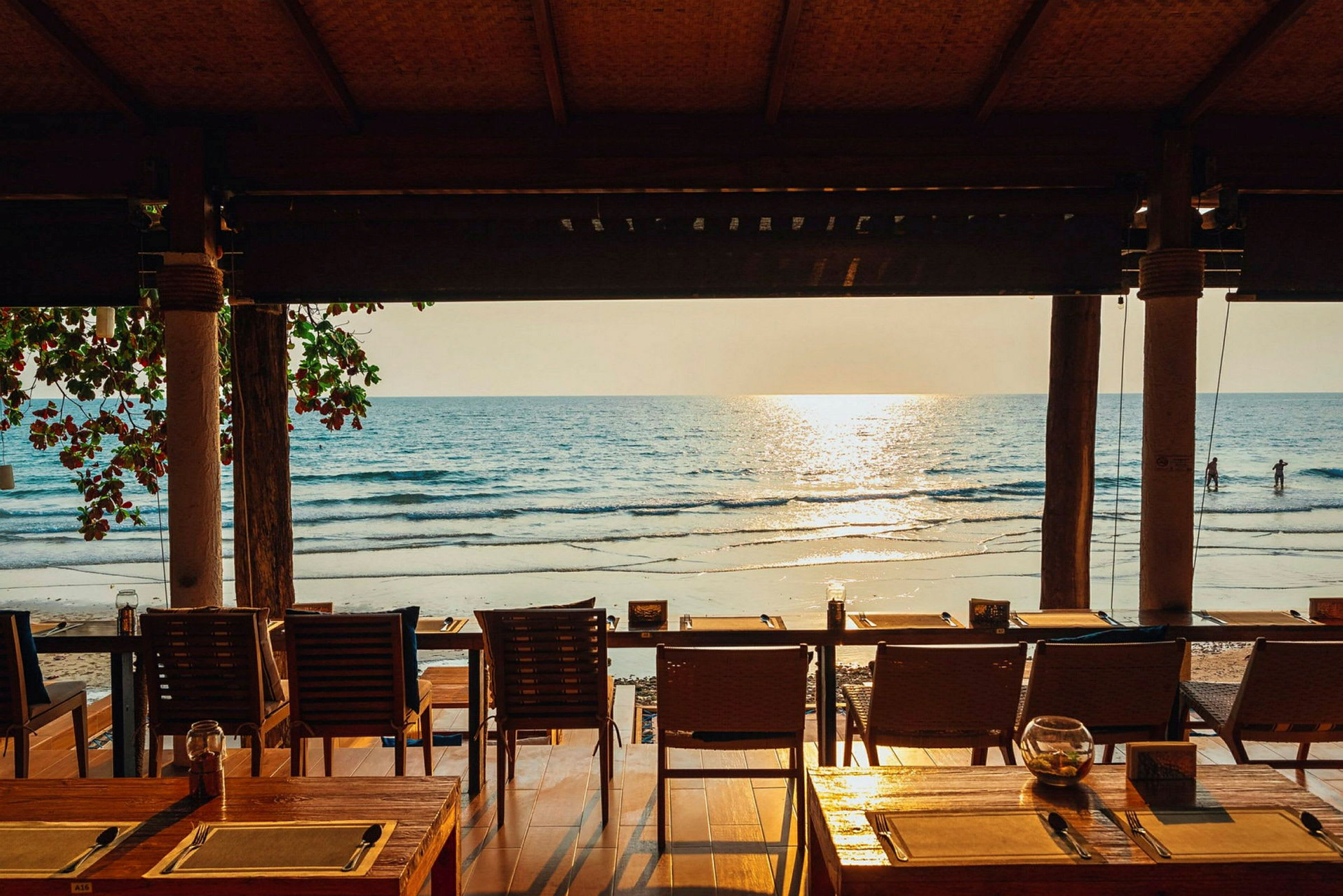 En restaurant med udsigt over stranden og havet i solnedgangen. (AI-genereret tekst)