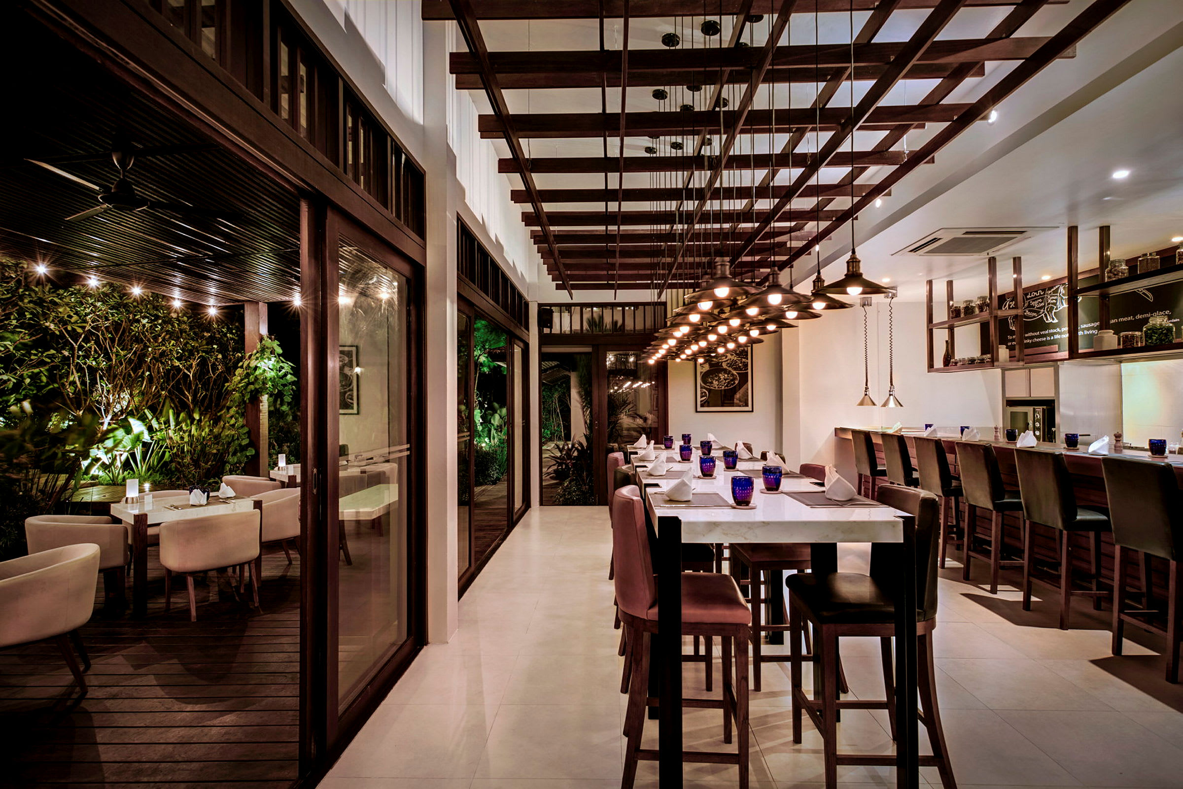 En moderne restaurant med elegante trædetaljer og både indendørs og udendørs siddepladser. (AI-genereret tekst)