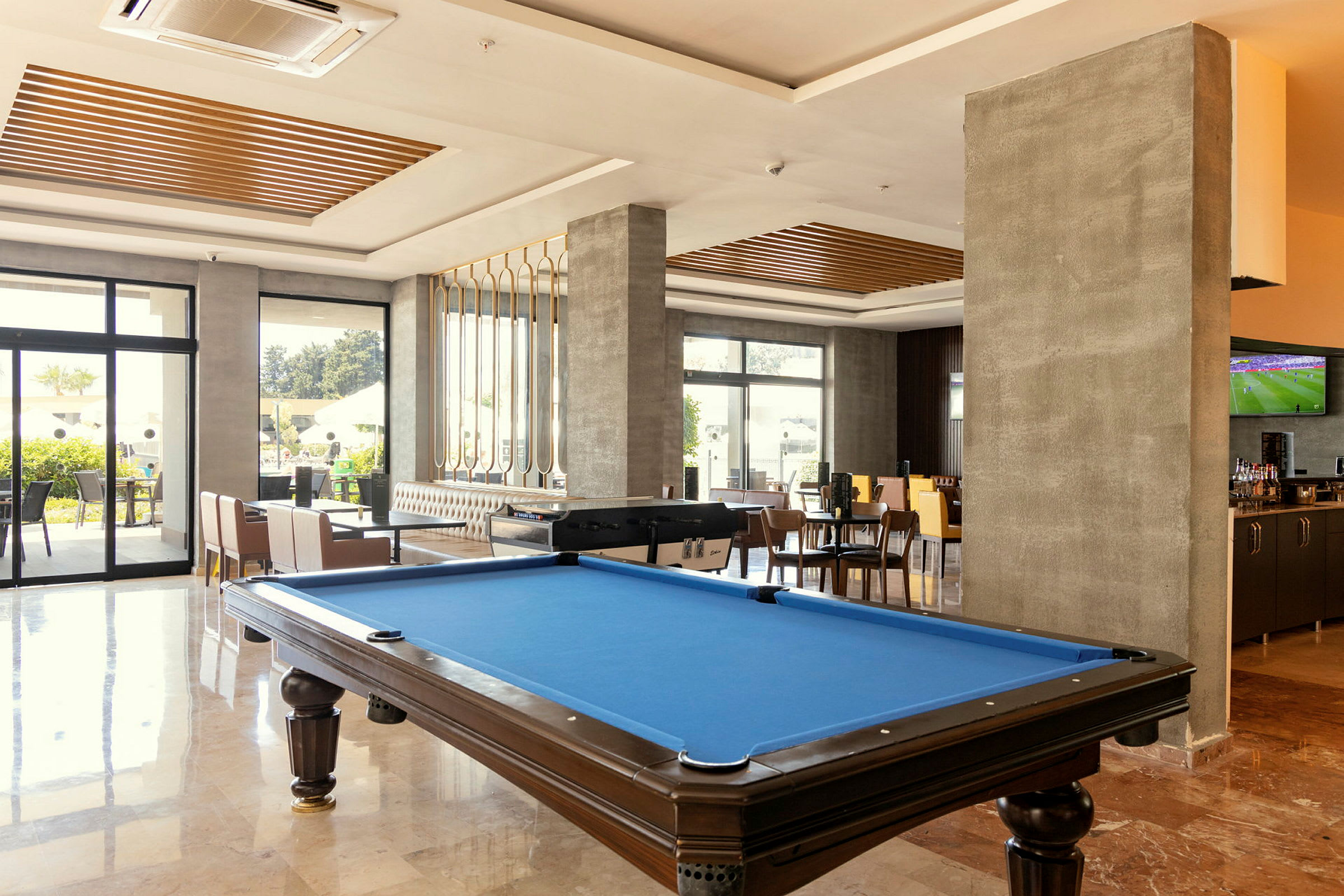 Et moderne rum med billiardbord, siddepladser og en bar. (AI-genereret tekst)