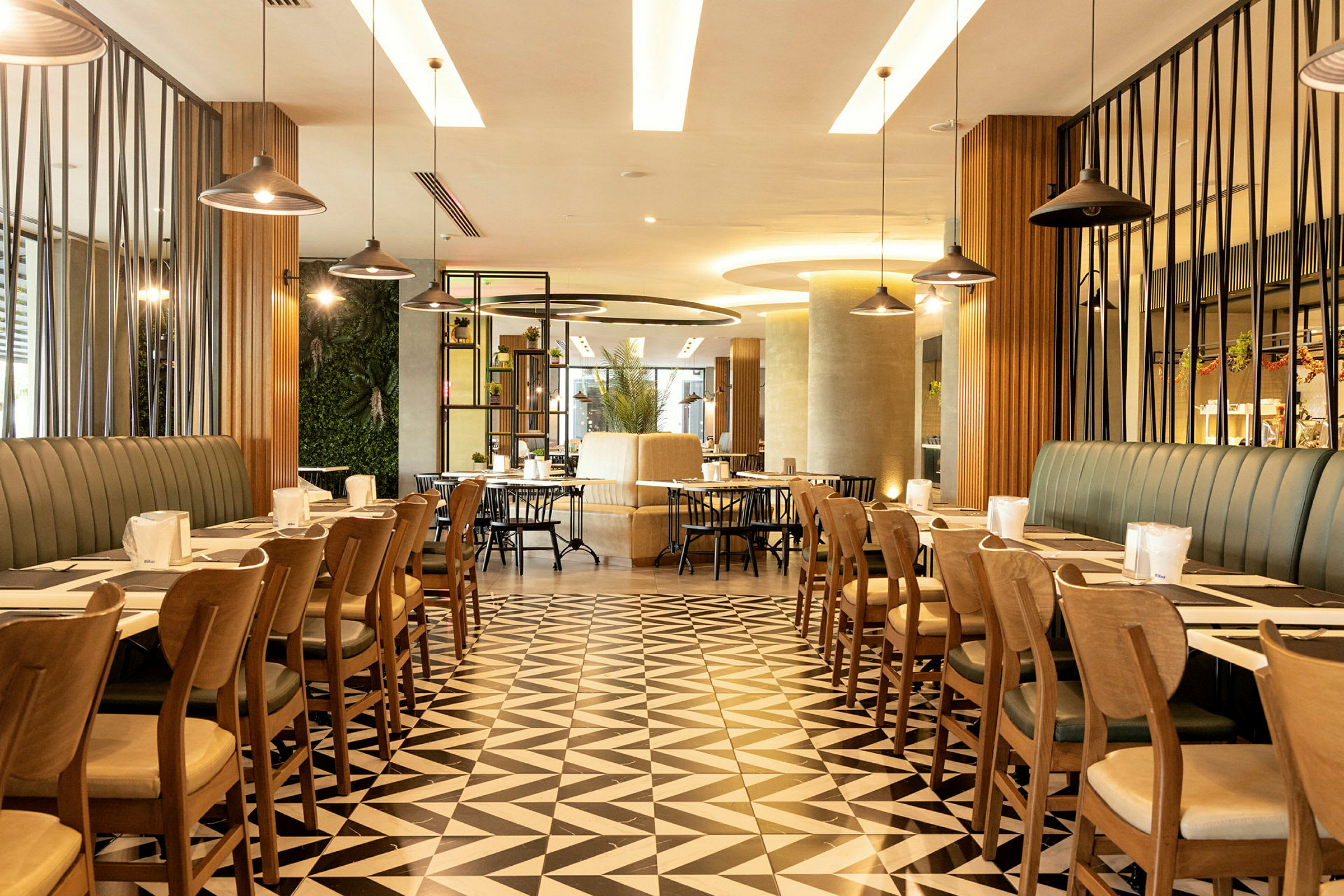 En moderne restaurant med geometriske gulvfliser, stilfuld indretning og borde organiseret til servering. (AI-genereret tekst)