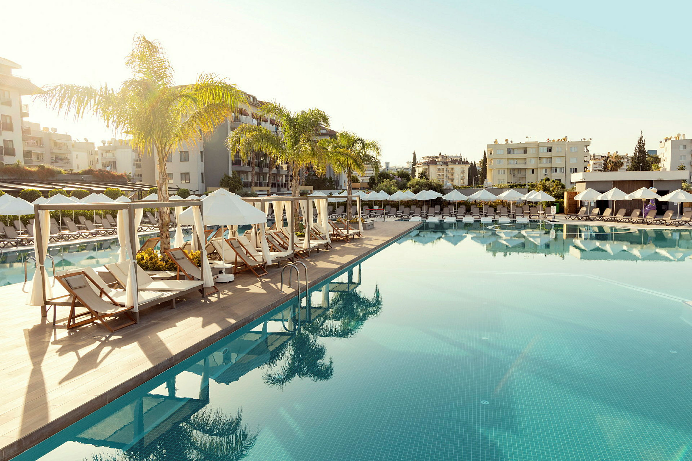 En pool med liggestole og parasoller i en resorts miljø. (AI-genereret tekst)