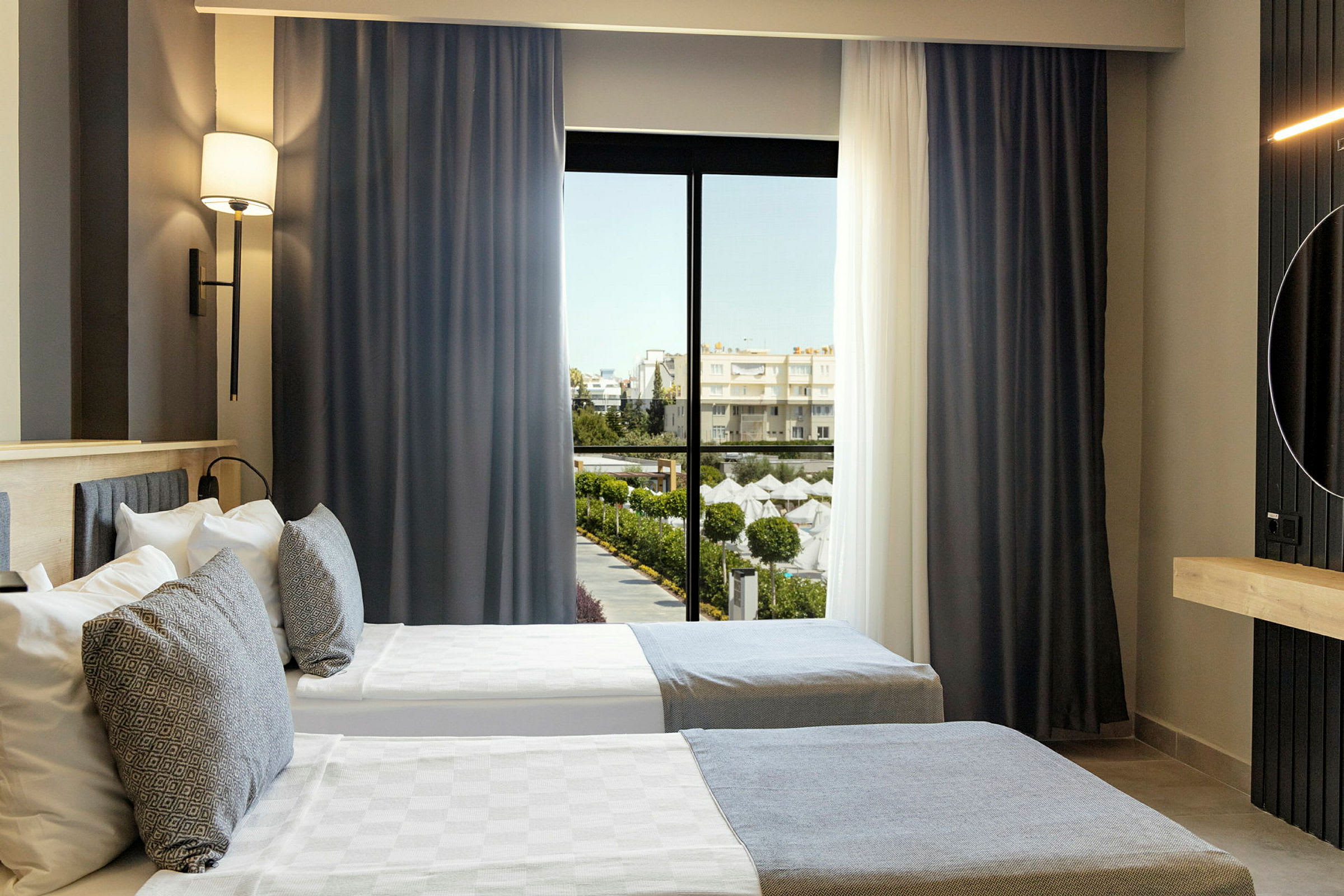 Hotelværelse med to enkeltsenge og vindue med udsigt til et poolområde. (AI-genereret tekst)