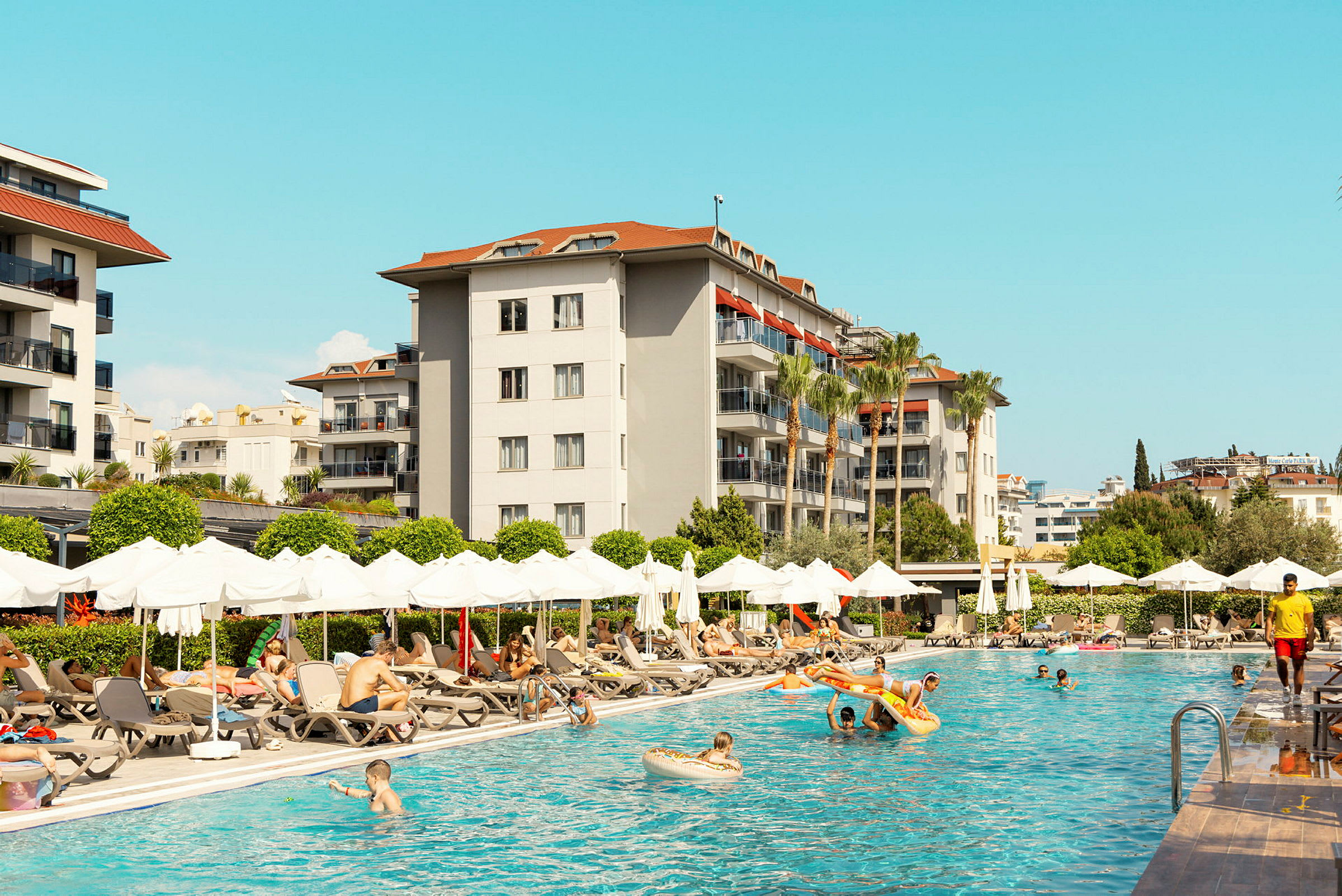 Udendørs poolområde ved hotel med liggestole og parasoller. (AI-genereret tekst)