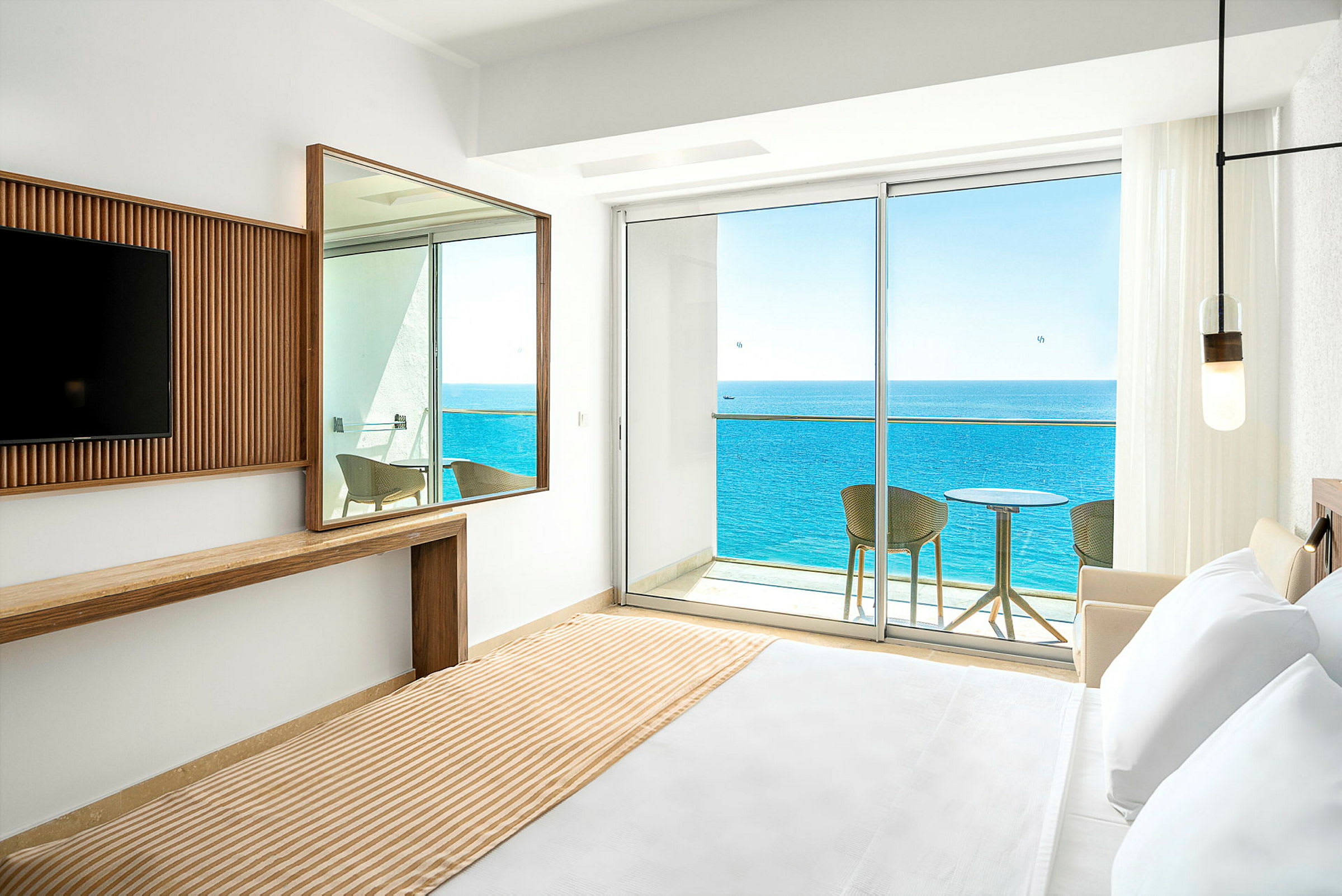 Hotelværelse med udsigt over havet fra altan. (AI-genereret tekst)