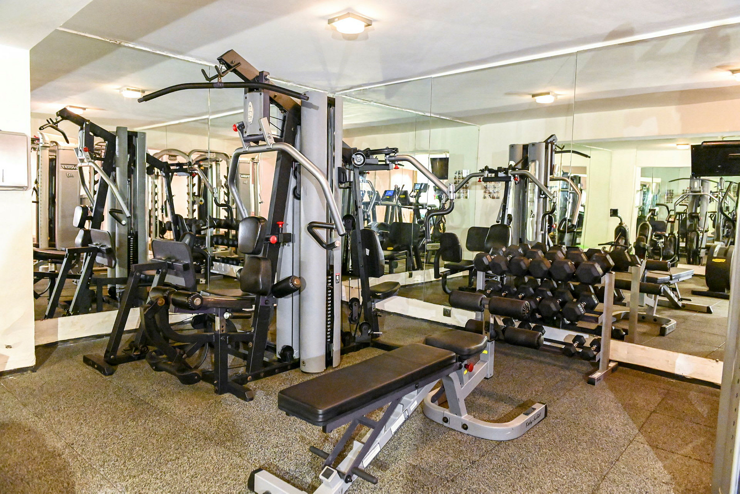 Billede af et fitnesscenter med træningsmaskiner og frie vægte. (AI-genereret tekst)