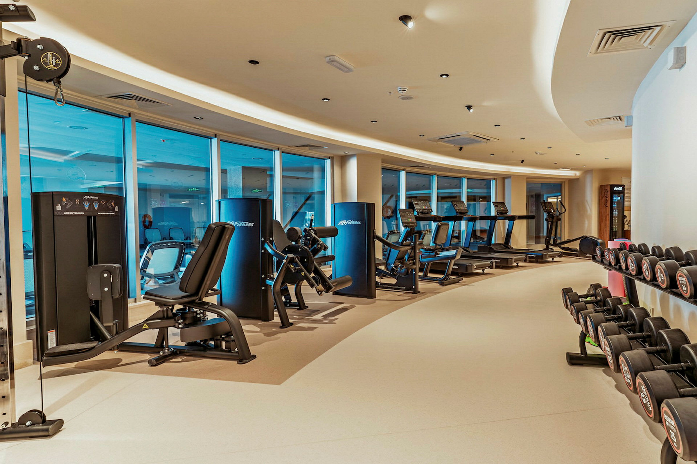 Moderne fitnesscenter med træningsmaskiner og håndvægte. (AI-genereret tekst)