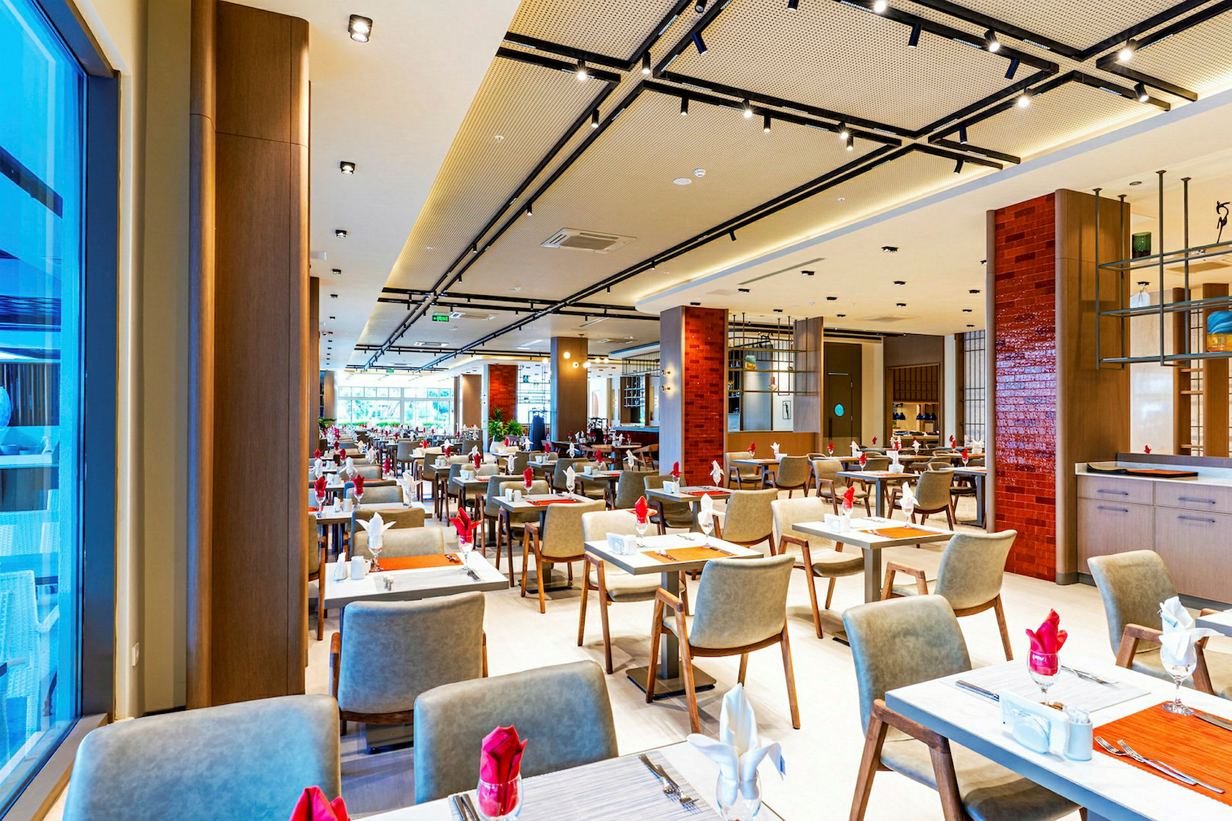 Billede af en elegant restaurant med mange dækkede borde og moderne møbler. (AI-genereret tekst)