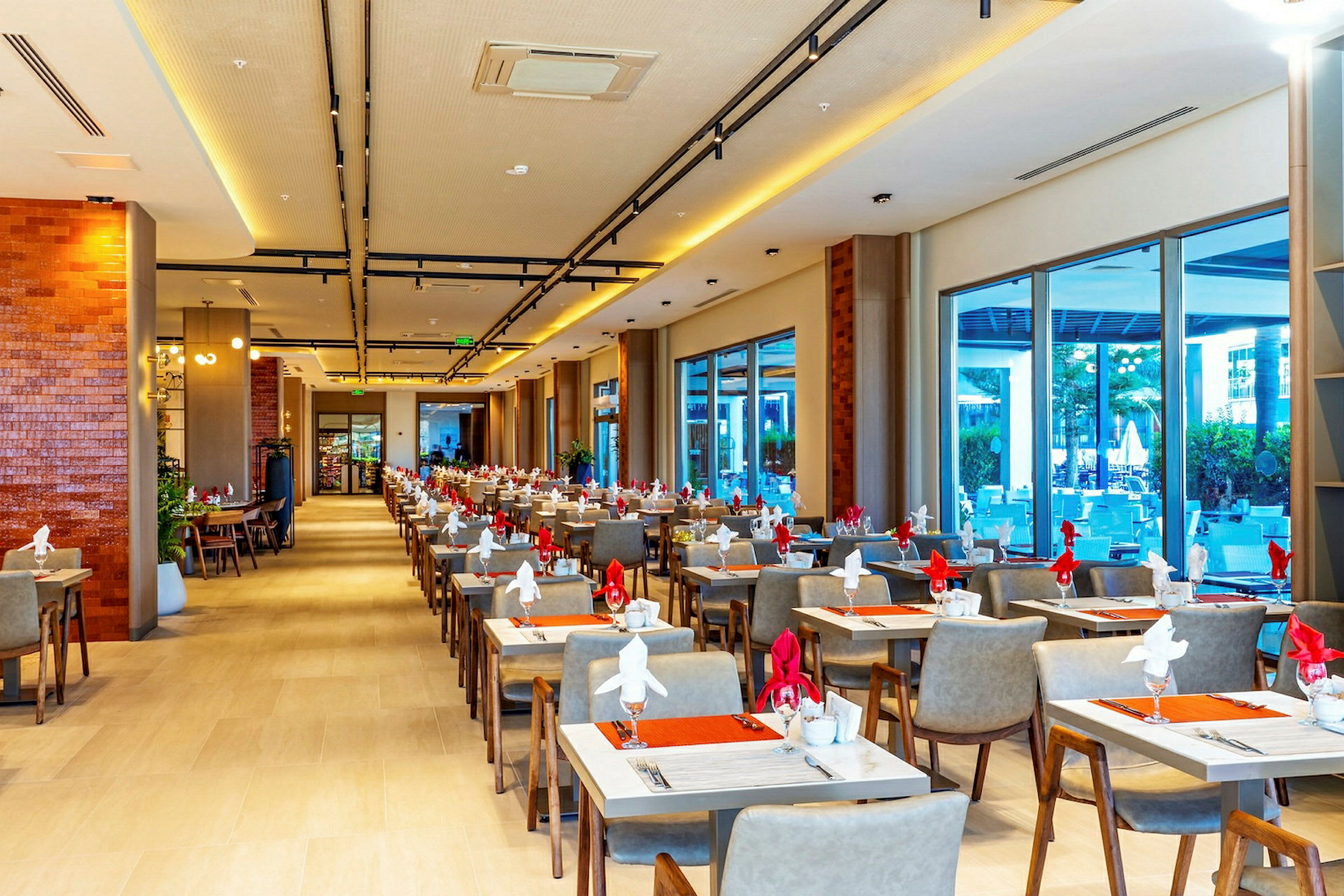 En lys restaurant med dækkede borde og moderne møbler. (AI-genereret tekst)