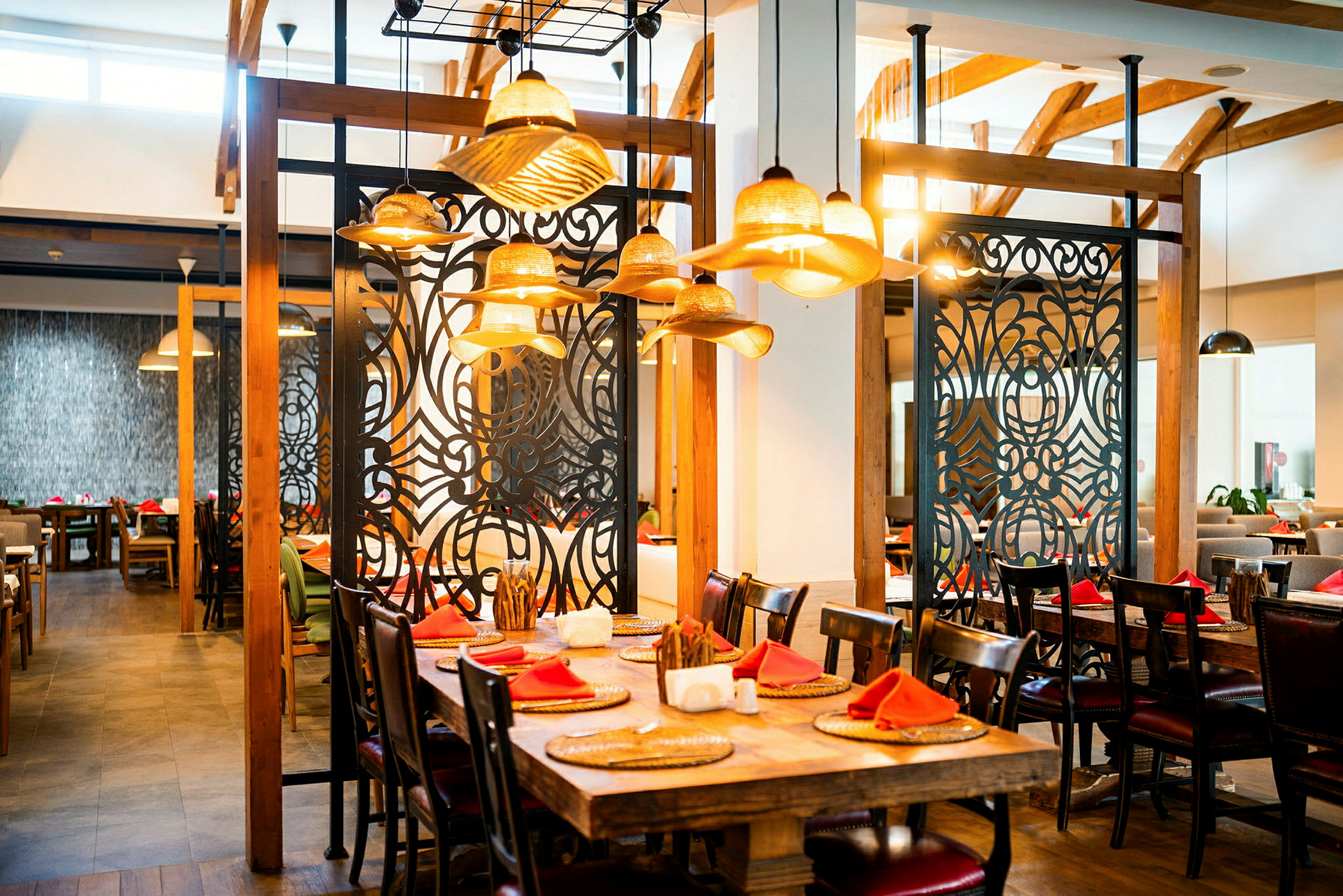 En restaurant med træindretning, dekorerede sort-hvide afdelere og dækkede borde med røde servietter. (AI-genereret tekst)