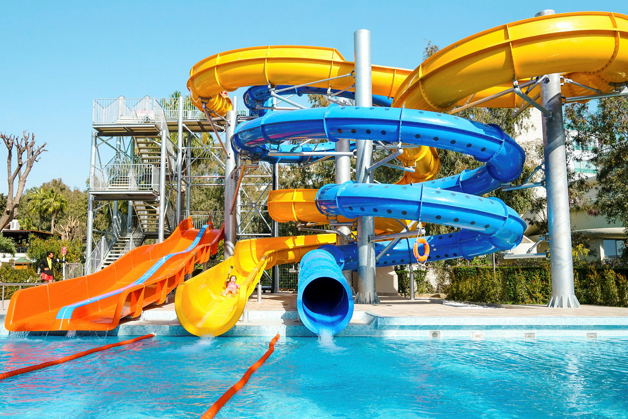 En vandpark med farverige vandrutsjebaner ved en pool. (AI-genereret tekst)