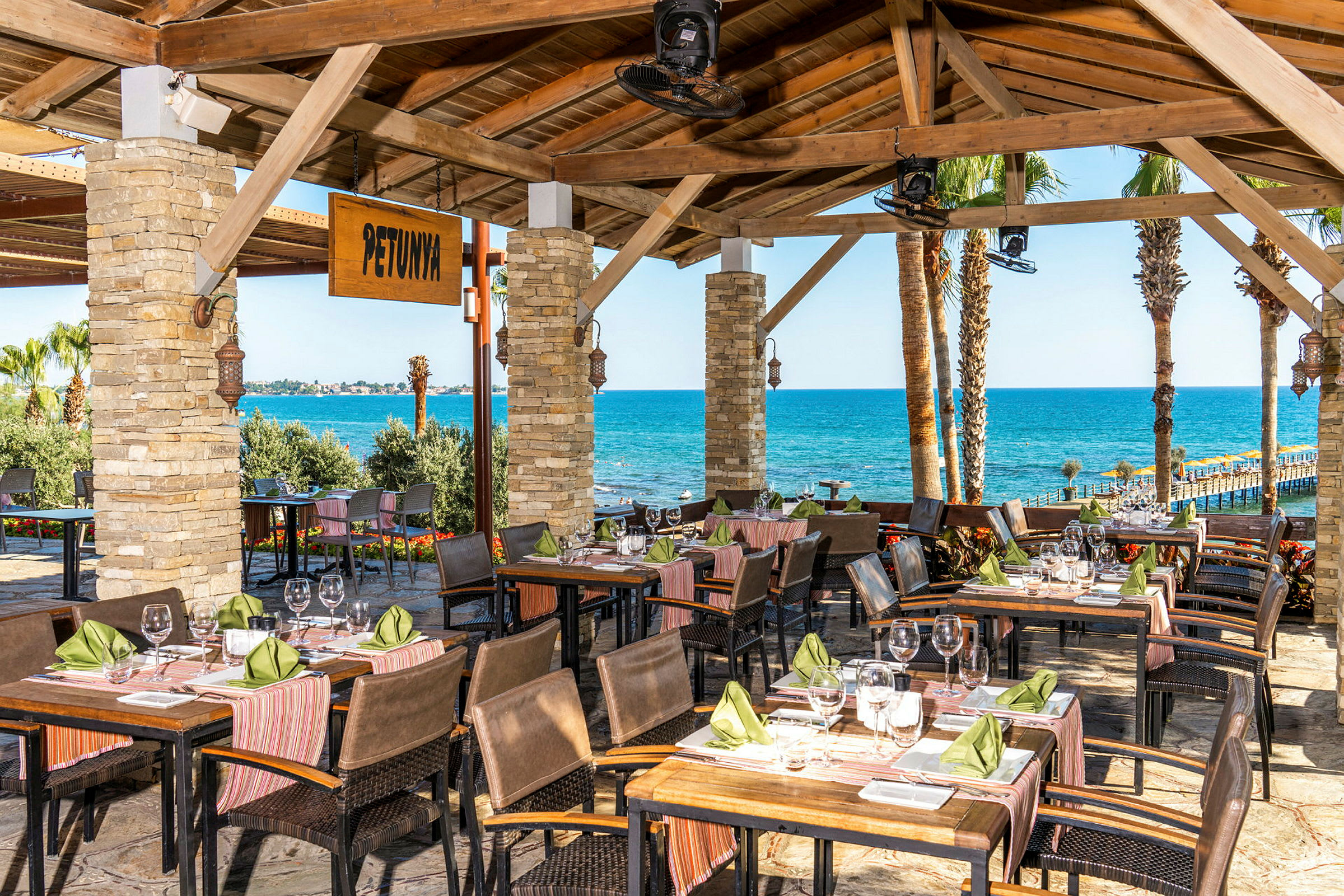 En restaurant med udsigt over havet og palmetræer. (AI-genereret tekst)