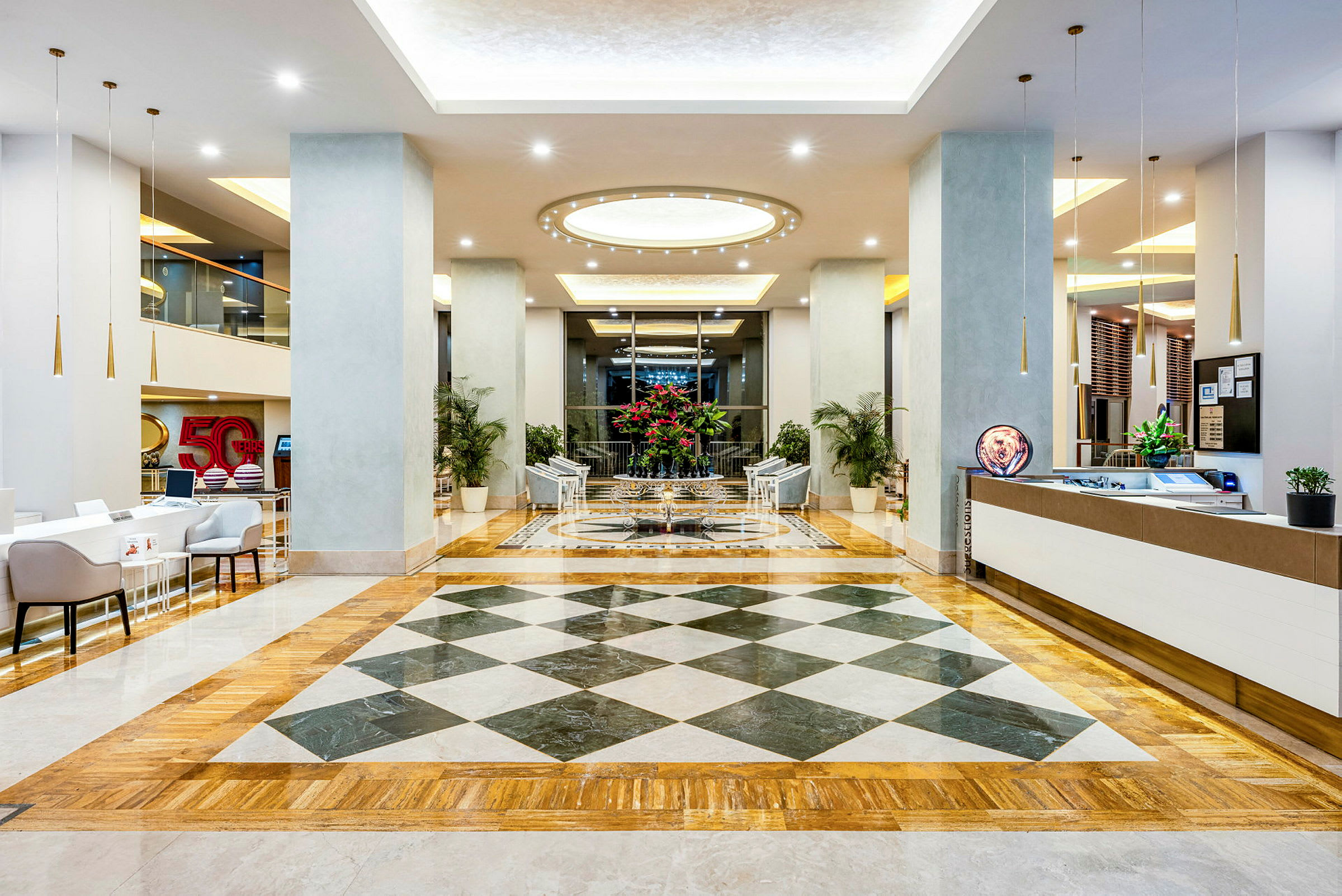 Hotellets foyer med siddeområde og reception. (AI-genereret tekst)
