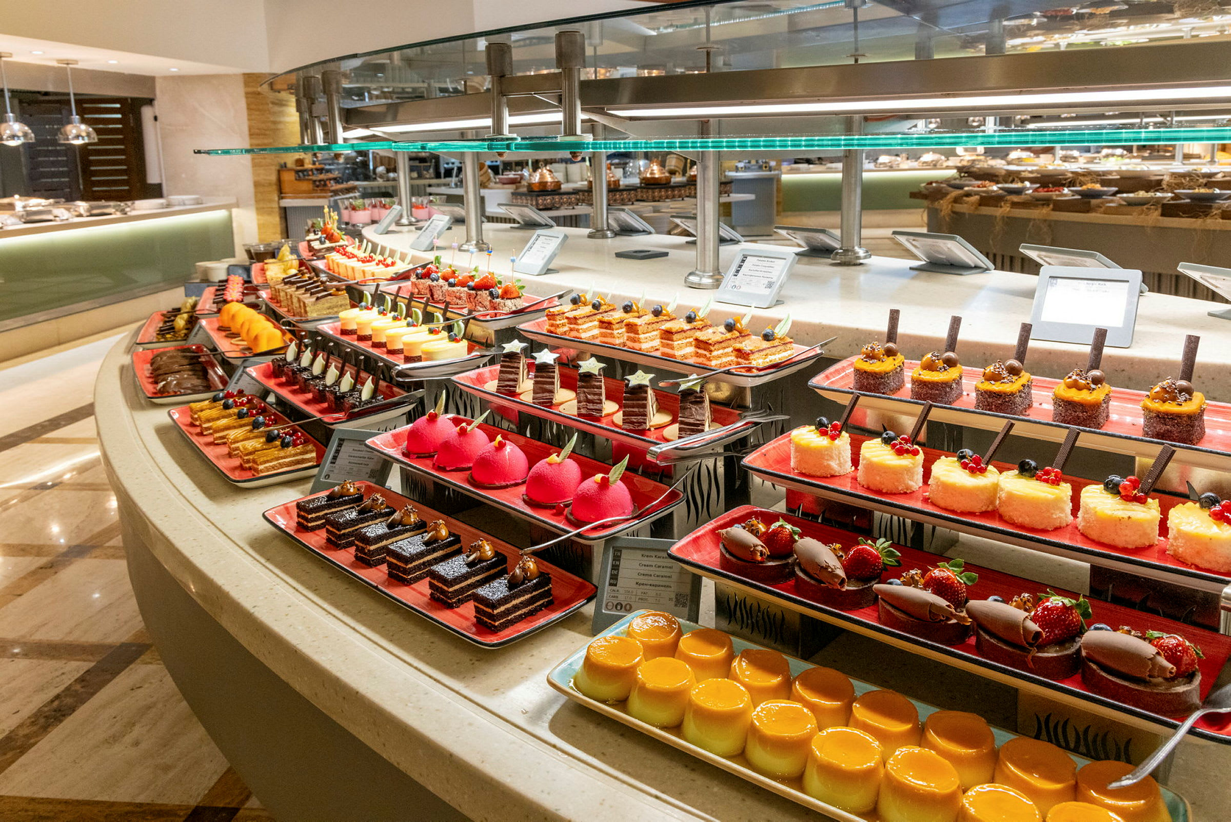 En buffet med forskellige desserter, herunder kager, panna cotta og små bagværk. (AI-genereret tekst)
