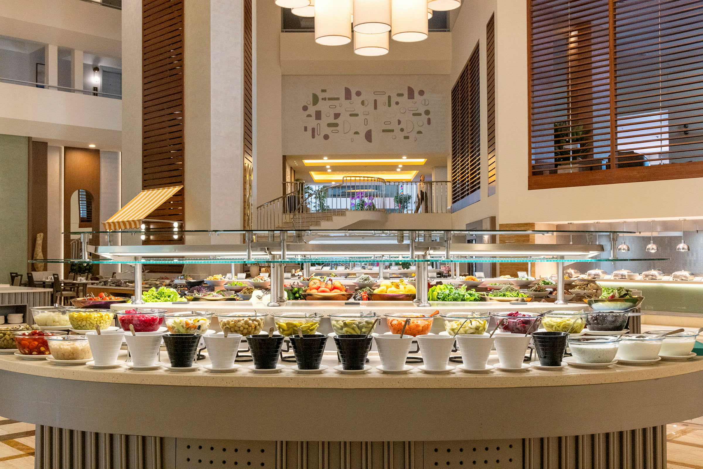 Billede af en buffet med et udvalg af friske grøntsager og andre retter i en veloplyst spisesal. (AI-genereret tekst)