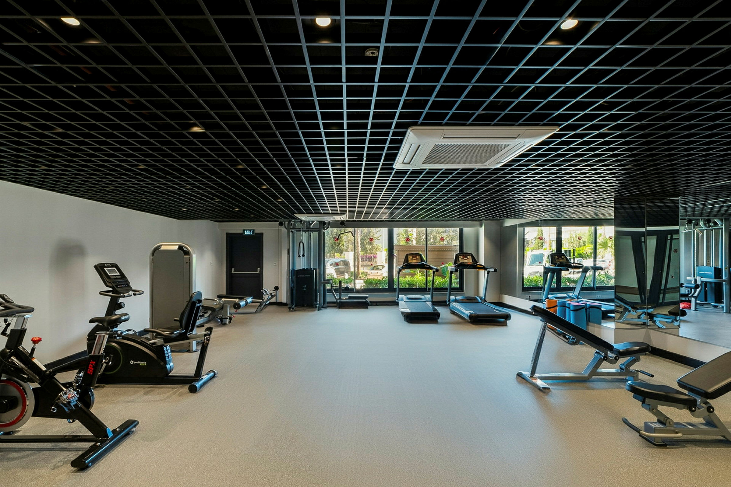 Et fitnesscenter med træningsudstyr såsom løbebånd, motionscykler og styrketræningsmaskiner. (AI-genereret tekst)