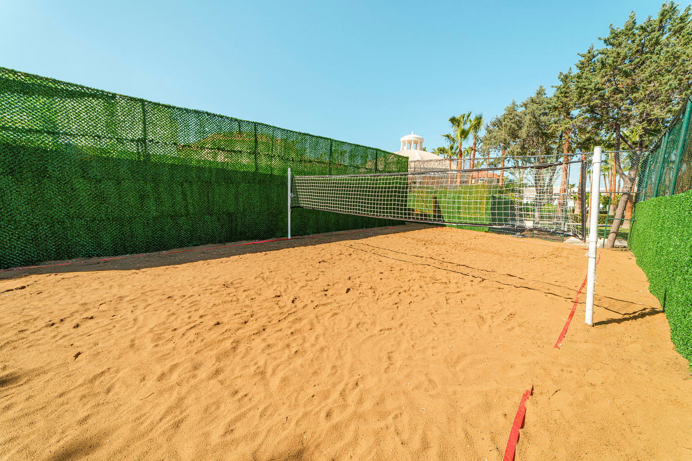 En sandbane med et net til volleyball. (AI-genereret tekst)