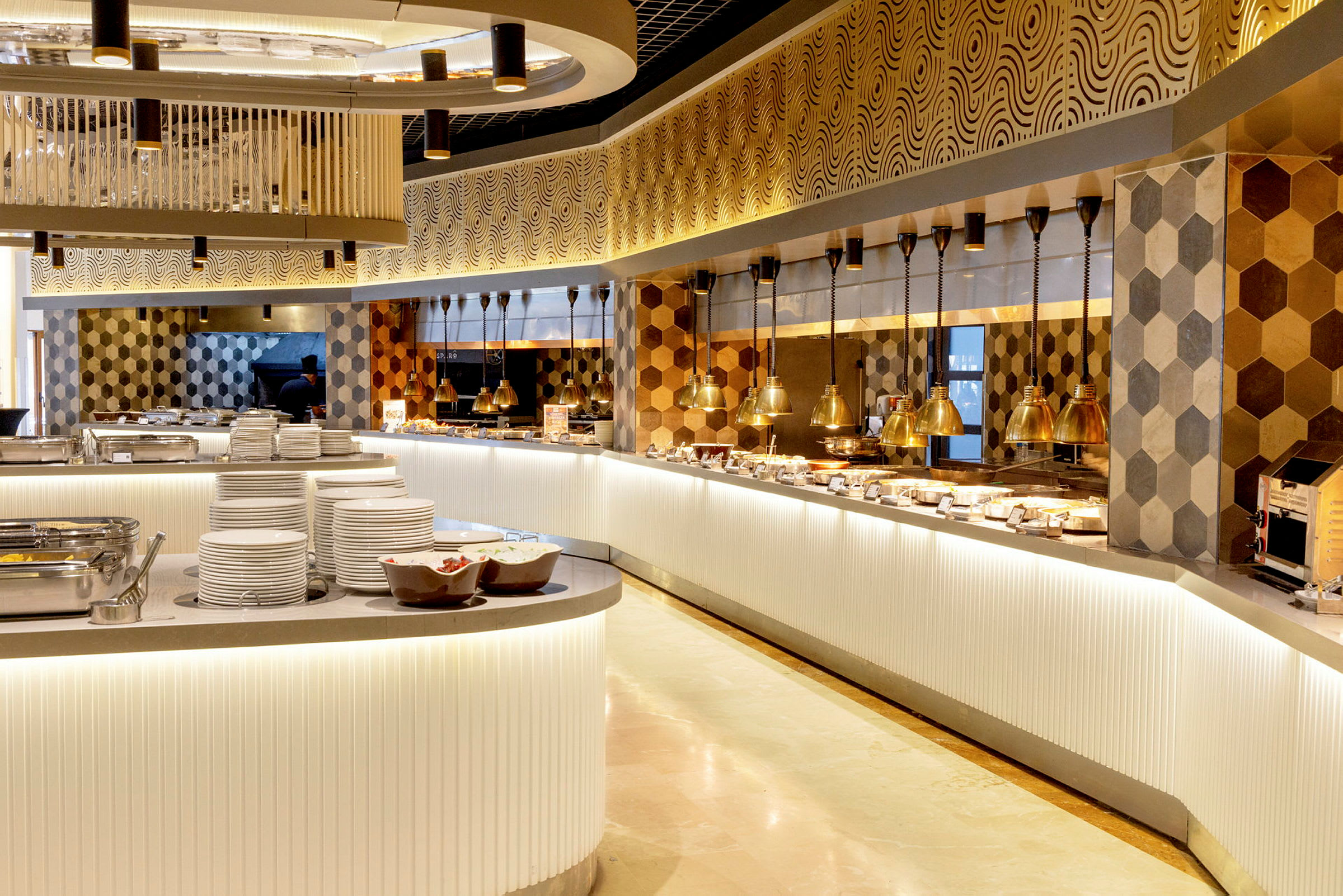 En elegant buffetopstilling i en restaurant med moderne, varme farver og sekskantede fliser på væggen. (AI-genereret tekst)
