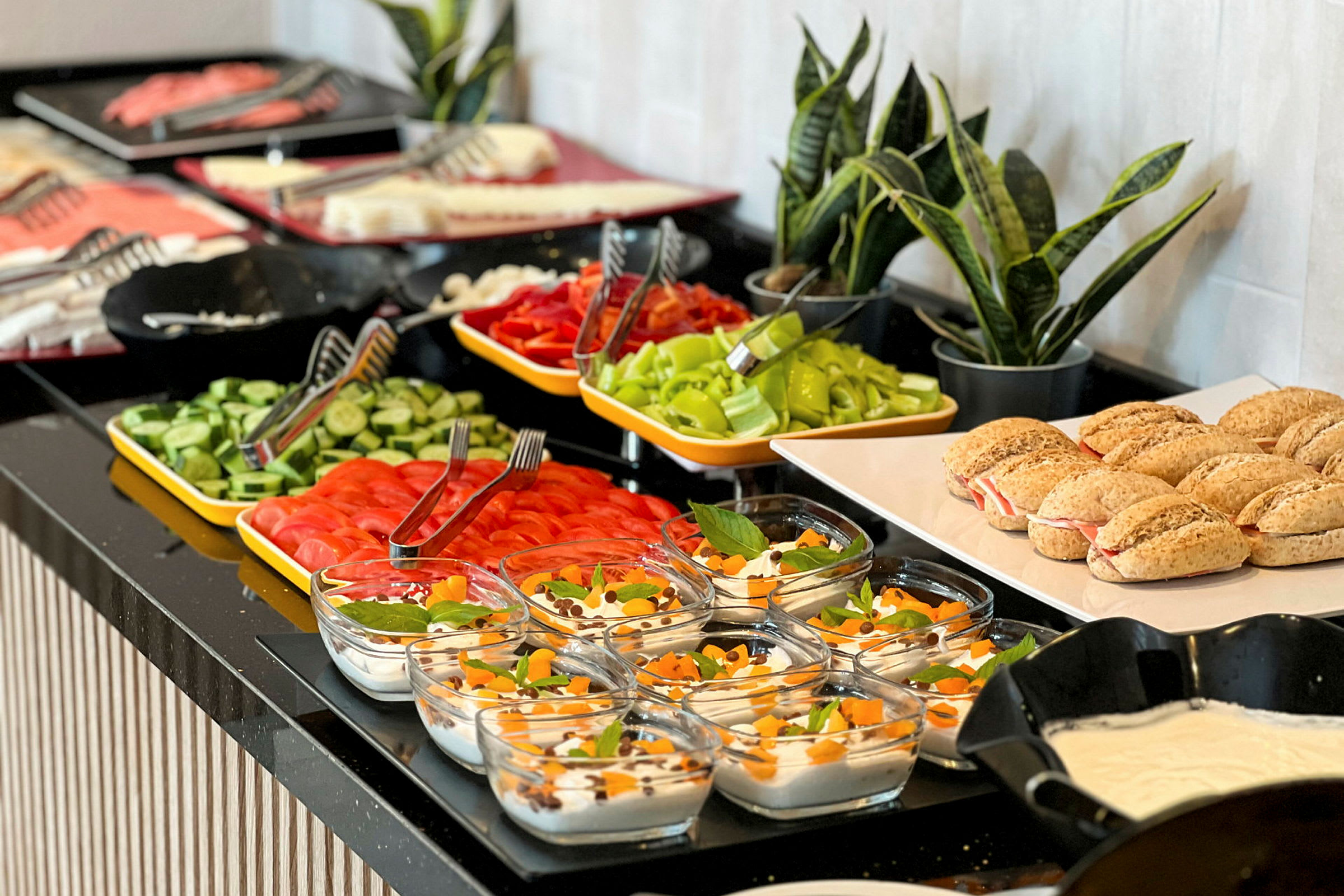 Billede af en buffet med forskellige retter inklusive brød, grøntsager og desserter. (AI-genereret tekst)