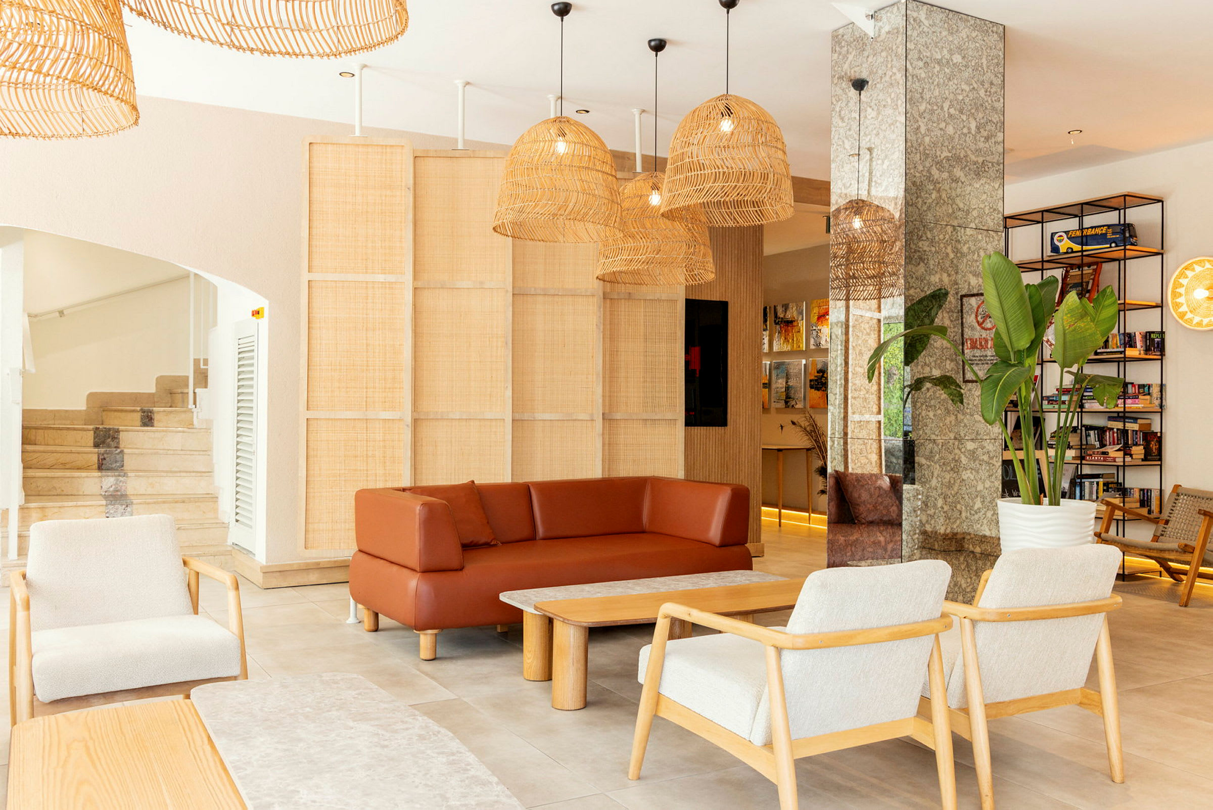 En lys og moderne stue med sofaer, stole og et sofabord. Plantedekorationer og bøger er synlige i baggrunden. (AI-genereret tekst)