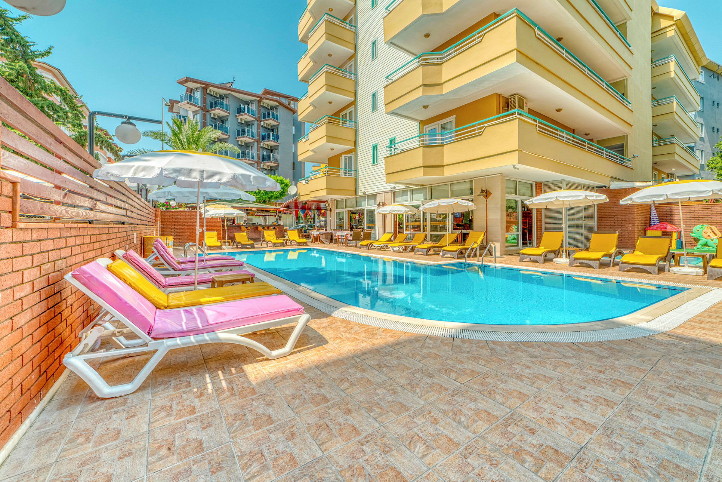 Udendørs pool med liggestole og parasoller ved et moderne hotel. (AI-genereret tekst)