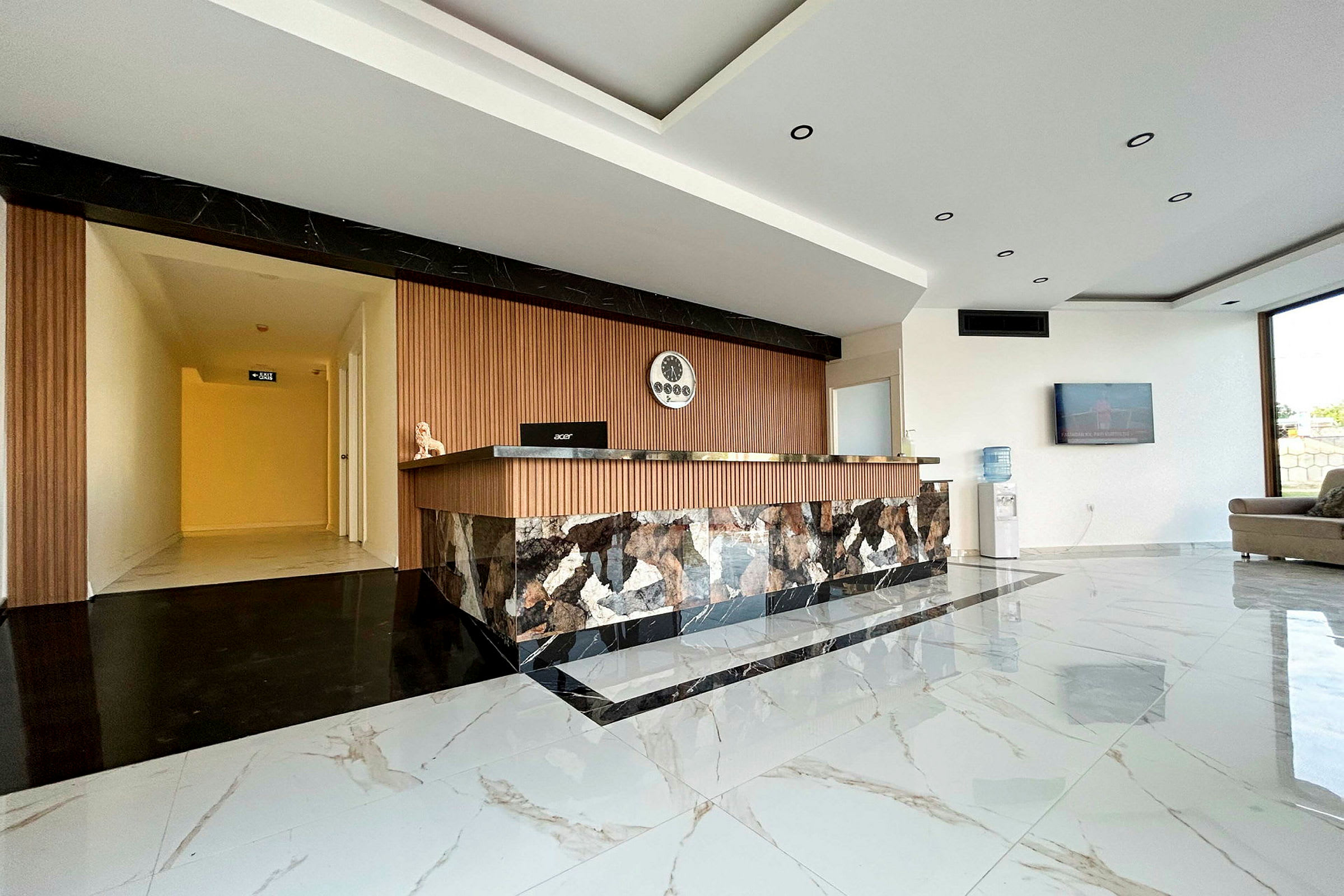 Indgangsområde med moderne reception, marmorgulv og vægge. (AI-genereret tekst)
