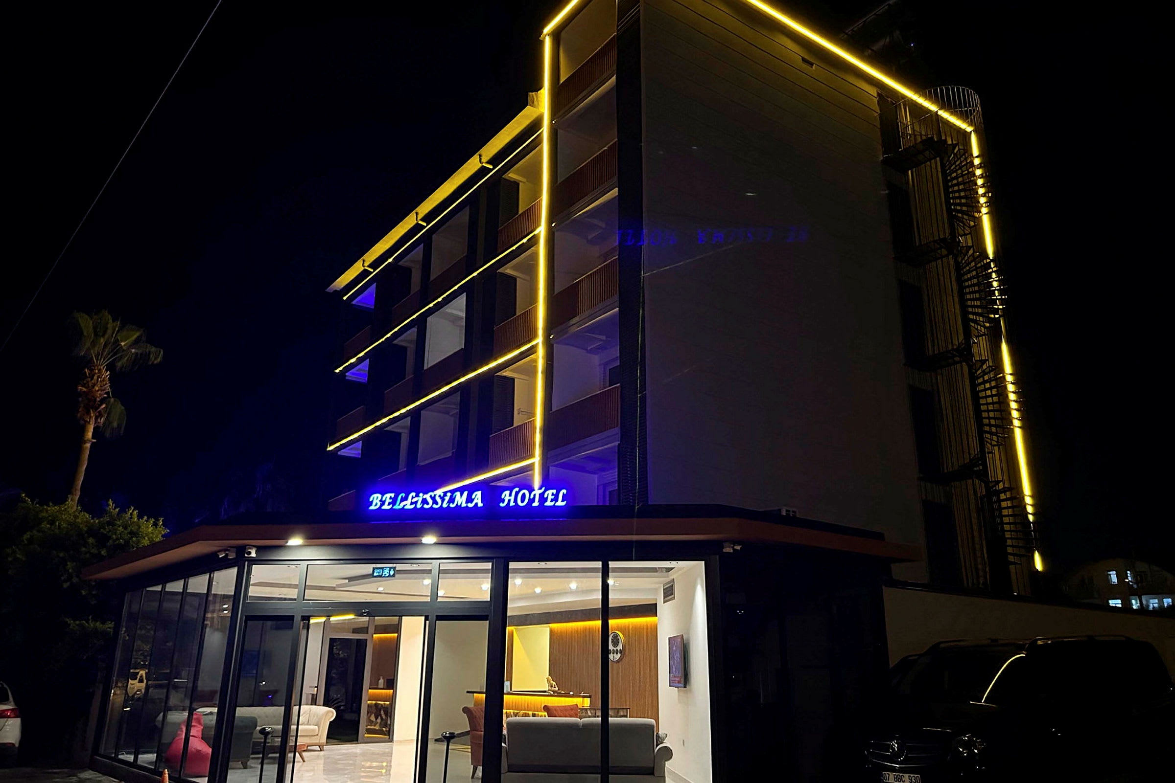 Hotelbygning med lysende skilt og facadebelysning, fotograferet om natten. (AI-genereret tekst)