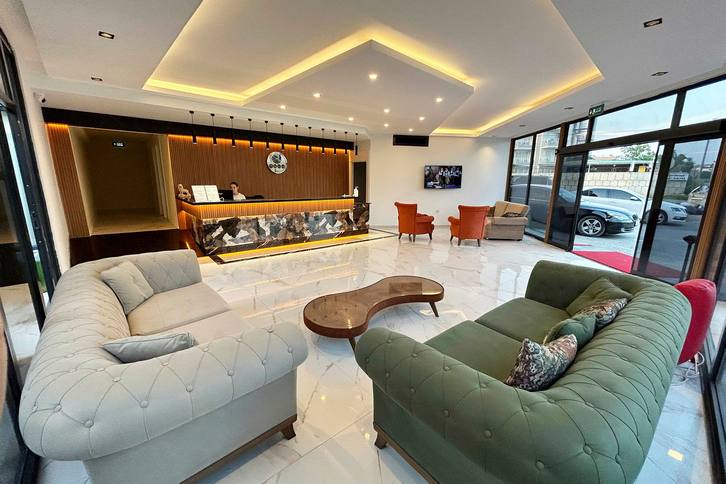Et hotellreceptionsområde med sofaer, lænestole og en moderne receptionsskranke. (AI-genereret tekst)