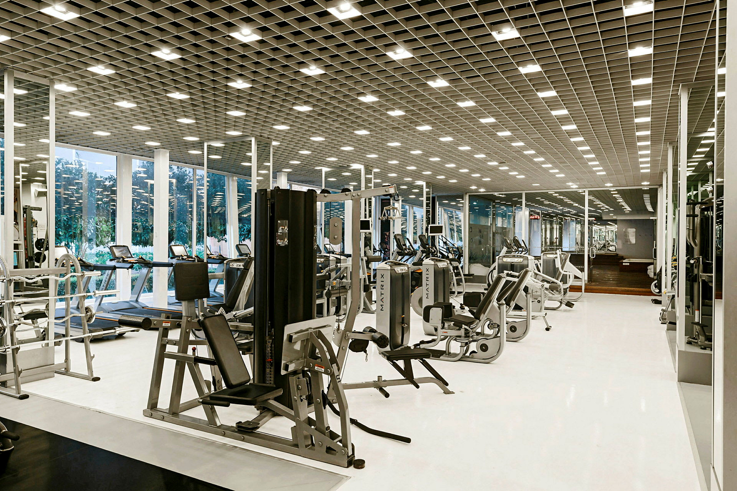 Et moderne fitnesscenter med træningsudstyr og spejlvægge. (AI-genereret tekst)