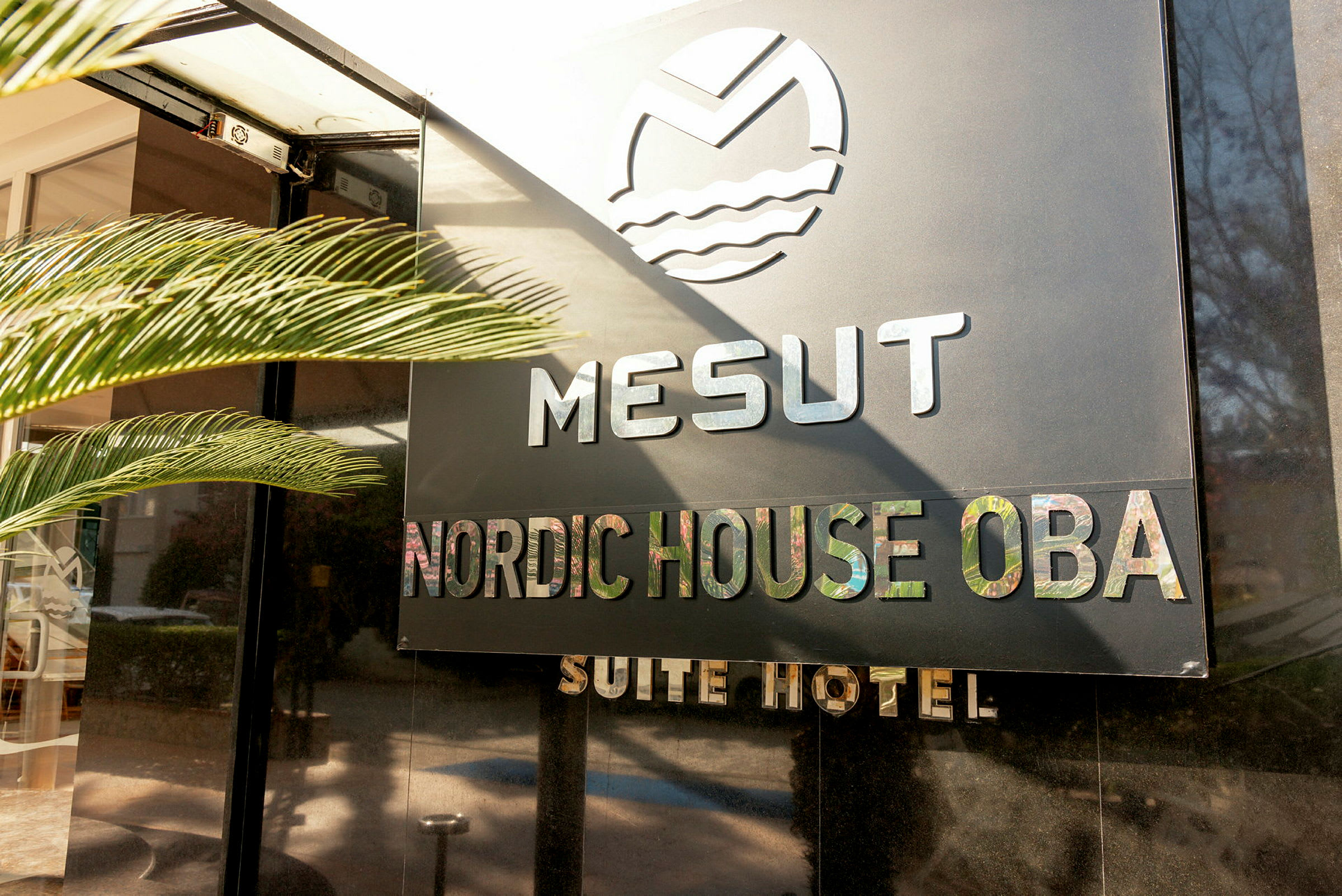 Hotelskilt med teksten Mesut Nordic House Oba Suite Hotel. (AI-genereret tekst)