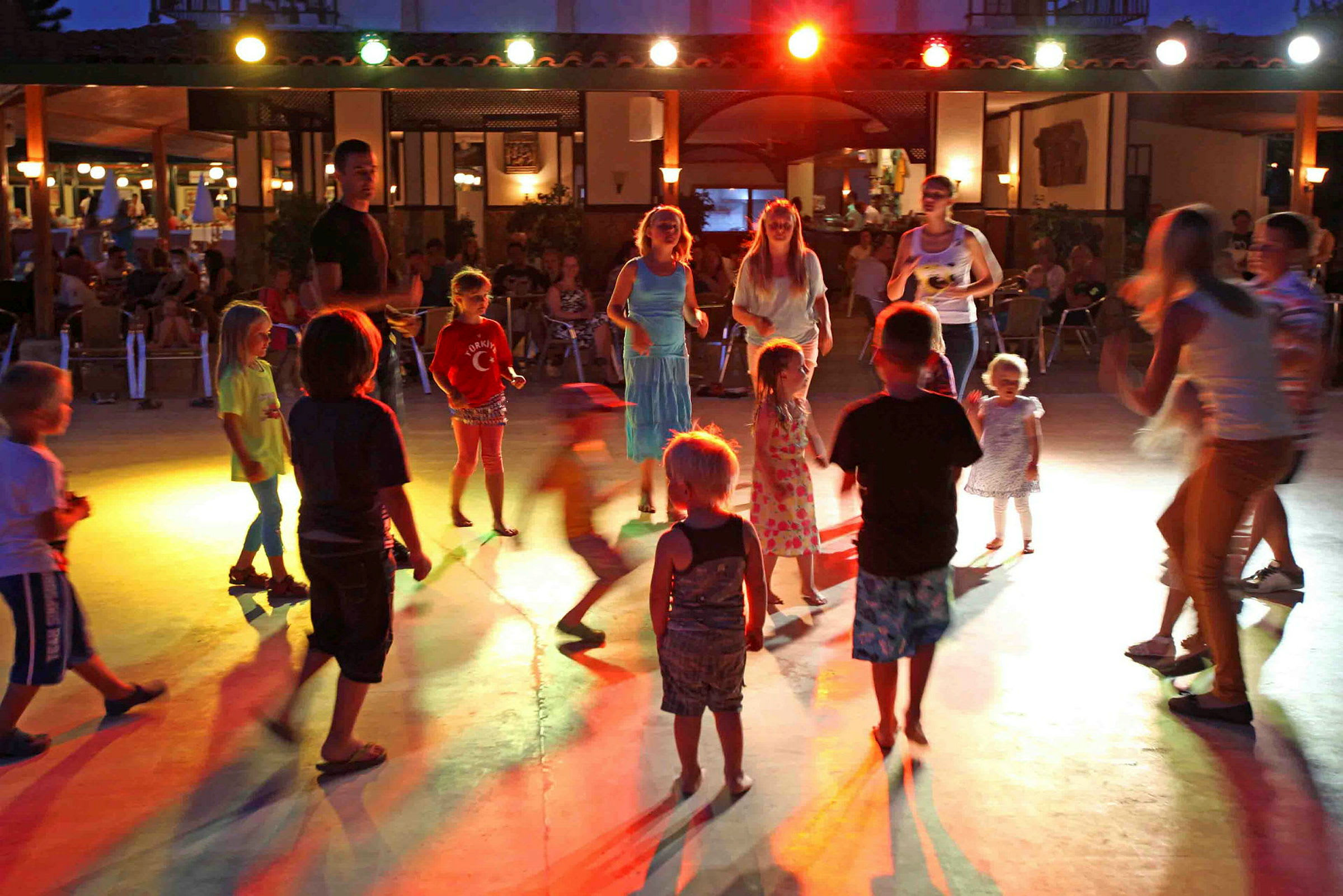 Børn danser på en oplyst flade om aftenen. (AI-genereret tekst)