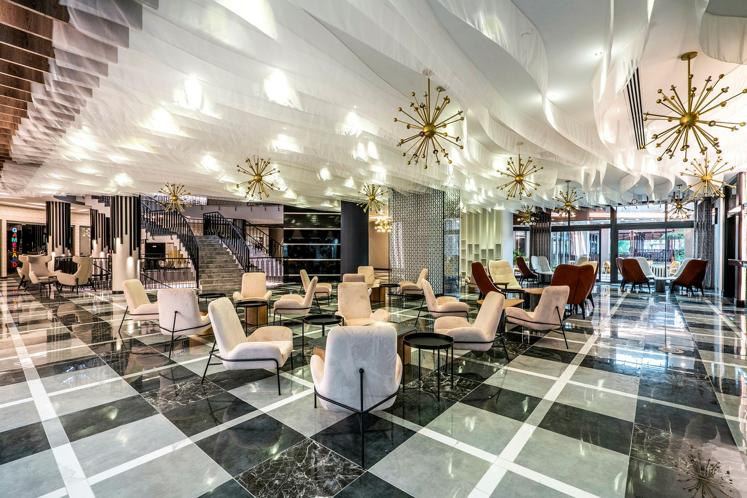 En rummelig og elegant hotelobby med komfortable siddepladser og moderne indretning. (AI-genereret tekst)