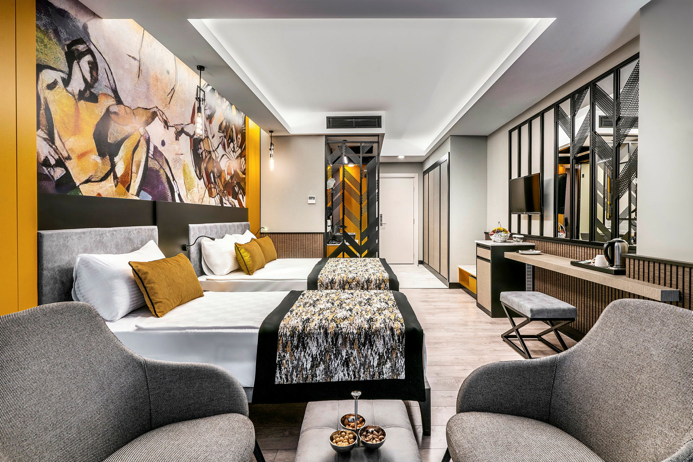 Moderne hotelværelse med to senge, siddeområde og kunst på væggen. (AI-genereret tekst)