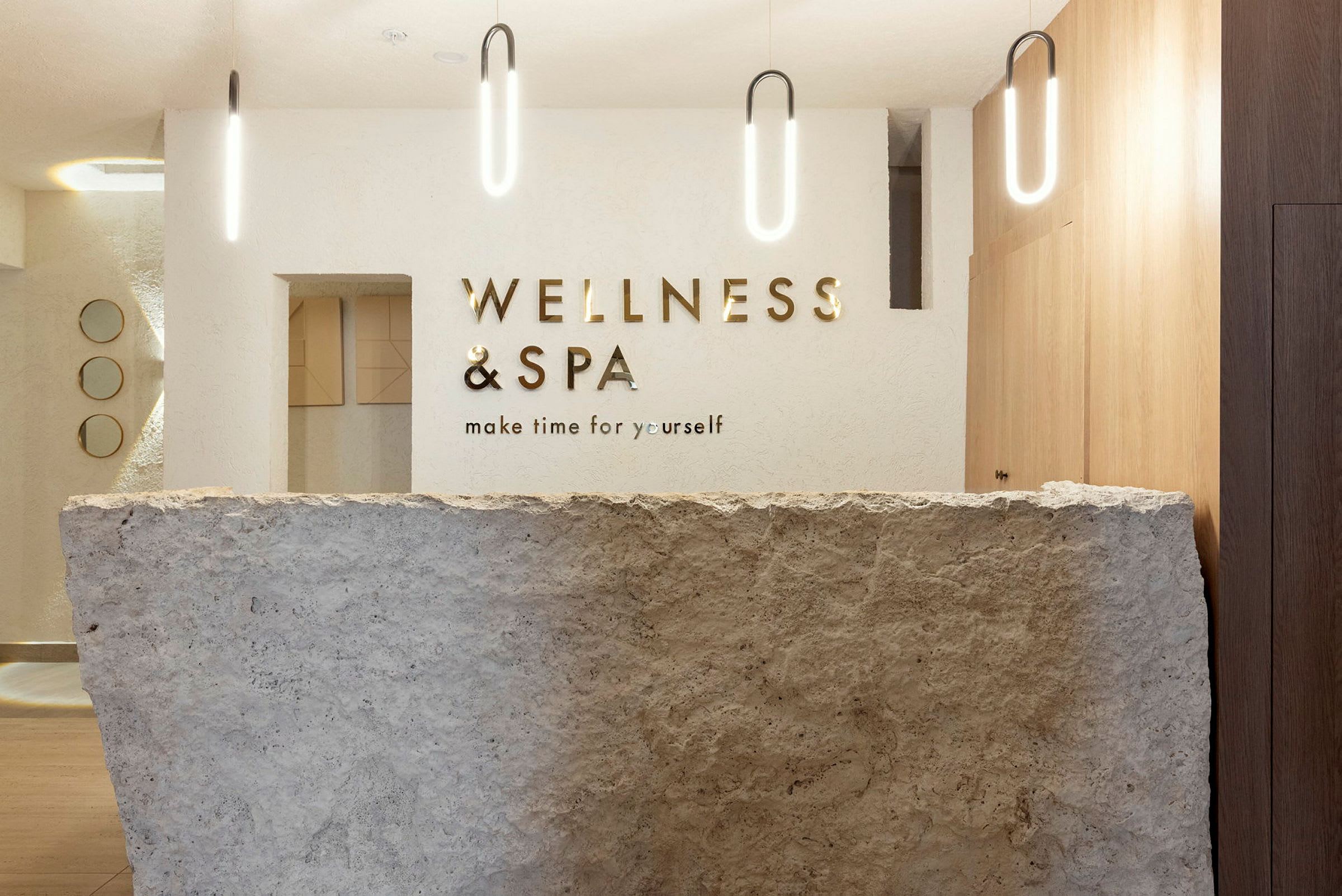 Receptionen på et spa- og wellnesscenter med en stenfront og moderne belysning. (AI-genereret tekst)