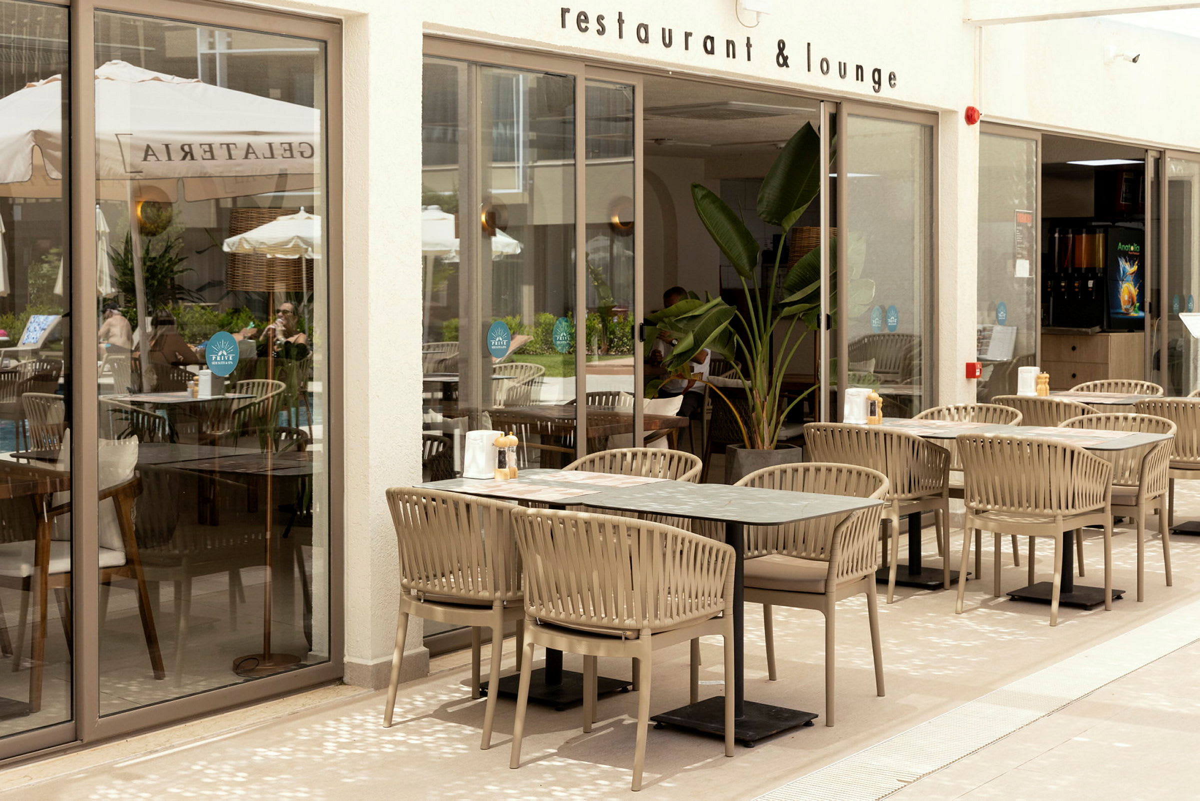 Udendørs område på en restaurant med borde og stole placeret på en terrasse. (AI-genereret tekst)